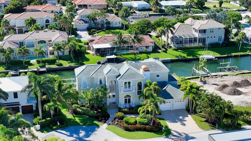 **OWNER READY TO SELL**Coastal Chic! AMAZING bay views throughout.  Enjoy the morning sunrise while lounging on the extra large master bedroom deck and take in all the sparkling beautiful blue open water. Boating, Beach and Golfing is the lifestyle of Country Club Shores! (Join the LBK club just across Gulf of Mexico Dr for Golf, Tennis, social membership with 265 days of events.  You won't forget to enjoy the wonderful open bay views from just one home in from end point off cul-de-sac.  Relax by the gas heated pool/spa with LED lighting and Screen logic w/cell phone operation for gas heater, lights & spa. Plenty or room for all your toys! 2 boat lifts, one 16K# and one 13K# plus 2 jet ski lift (2 new motors in 2022). 2 back balconies with seating for relaxation plus plenty of room on the pool level for outdoor cooking & entertainment. 2 separate sunning areas plus the composite dock with water & electric. Help light up your evening with ground lights along paver paths front & back. When you stroll through the home you will enjoy the modernized, bright and light feel throughout. Tasteful decorating with new bedrooms plus family room furniture and assorted art all included in turnkey fashion. Fun purple tray lights in Dining & family room plus kitchen. Control the HEOS music system with speakers throughout home & off deck w your cell phone.  Eat-in gourmet kitchen with Viking appliances, wine fridge in center island & breakfast bar just off back raised patio. Open concept kitchen with 5 gas burner cook top, built-in oven and microwave, built-in Vicking fridge, pantry, wet bar, new light fixtures, cool purple lights in tray ceilings. Yell down off the master bedroom patio to give an order to the grill master. 2nd story Master en-suite includes an amazing bathroom with double vanities plus makeup/vanity area. Tons of storage, large walk-in shower plus garden tub. The master closet is extra large with surround cabinets, center island and coffee area with mini fridge. 2nd floor you will also find 2 more guest en-suite bedrooms and den/TV room. Bench seating in the hall to gaze out the window. 1st floor has 1 en-suite guest room with pool bath, plus bonus room owners use as the gym. Two cabinets plus beverage fridge run along the back wall and can have multiple uses . Home offers natural gas fireplace in front formal living room next to the formal dining room with plenty of room to seat 8. Tall windows & doors including high transoms in most living areas to bring in the Florida sun. Elevator lands on garage, 1st and 2nd floors. Deeded beach access just across the pedestrian walkway on Gulf of Mexico Dr between BeachPlace and LBK club.