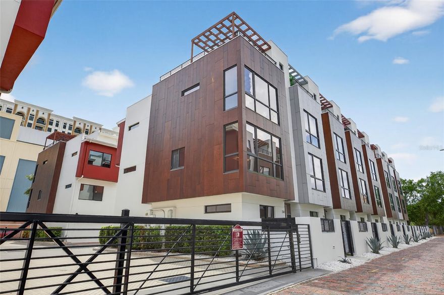Bold. Modern. Downtown.

Welcome to your next-level lifestyle in the heart of Downtown St. Pete — where sleek design, smart living, and rooftop vibes collide at one unforgettable address.

Tucked inside a gated community, this stunning four-story corner-unit townhome isn't just a home — it's a statement. Enter through your private ground-level patio, the perfect spot for morning coffee, and step into bright, freshly repainted interiors that immediately set the tone for elevated living. Rich Mohawk wood flooring flows throughout, while floor-to-ceiling windows and corner-unit exposure flood every level with natural light from every direction.

At the heart of the home, an upgraded gourmet kitchen steals the show — featuring an extended island, double sink, stainless steel appliances, a gas cooktop, built-in microwave, and pull-out drawers. The open-concept design flows seamlessly into the main living area, creating the perfect environment for both lively entertaining and everyday ease.

Upstairs, the primary suite delivers comfort and style with two spacious walk-in closets, a double vanity, glass walk-in shower, and linen storage — your own private sanctuary to unwind. A dedicated laundry area on the primary level with front-loading washer and dryer keeps daily life seamless, and the private two-car garage with additional storage adds one more layer of everyday ease.

Designed for modern living, this home is fully equipped with smart locks and motorized blinds — offering convenience and peace of mind at every turn. RH furniture is negotiable, making this an effortless move-in opportunity.

And then there's the showstopper — your private rooftop terrace. Under the pergola, imagine evenings spent grilling, mixing cocktails at the wet bar, or catching the game with the Downtown St. Pete skyline as your backdrop. This isn't just an outdoor space — it's your personal rooftop oasis.

With a Walk Score of 93, you're perfectly positioned just two blocks from Central Avenue's vibrant restaurants, coffee shops, and boutiques, with effortless access to waterfront parks, the St. Pete Pier, and world-class museums. And when the beach calls, St. Pete Beach — along with Tampa International and Clearwater/St. Pete airports — is just a short 15-minute drive away.

This is more than a townhome — it's your front-row seat to the best of Downtown St. Pete living. Schedule your private tour today and step into the energy, elegance, and ease of your next home.