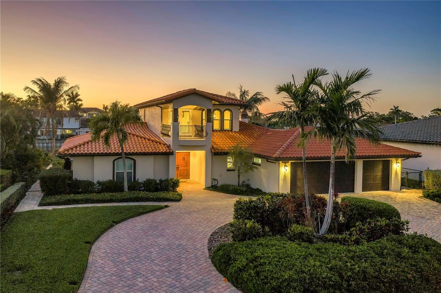 This beautifully updated waterfront residence offers a seamless blend of tropical elegance and modern luxury in the highly sought-after Venetian Isles community. With three spacious bedrooms and three impeccably designed bathrooms, this two-story home is thoughtfully crafted to maximize comfort while showcasing breathtaking views of downtown St. Petersburg. The first floor is designed for both everyday living and entertaining, featuring a chef’s kitchen equipped with premium Sub-Zero appliances, a Wolf gas cooktop and oven, a Bosch dishwasher, a wine refrigerator, granite countertops, backsplash, and a large center island/bar. Elegant travertine flooring flows throughout, leading into the inviting living room anchored by a tiled gas log fireplace and built in glass cabinets, complemented by hurricane-rated windows and doors for added security and peace of mind.  
A secondary primary suite on the main level offers a private retreat, complete with a generous walk-in closet and serene views of the pool and waterfront. An additional bedroom—currently used as an office—sits conveniently near a full bathroom just outside its entrance. The entire second floor is dedicated to the expansive primary suite, creating a true sanctuary. This space features an oversized walk-in closet, a private office, and two balconies—one facing the front and one overlooking the rear. The rear balcony captures stunning views of the canal, Tampa Bay, and the downtown skyline. Additional highlights include a water softener/filter, irrigation system, a tankless gas water heater for efficient, on-demand comfort, a spacious three-car garage with upgraded storage, and a grand circular paver driveway. Outdoor living is equally impressive. Boating enthusiasts will appreciate deep sailboat water access, a private dock, boat lift, and a newer seawall. The custom Gunite saltwater pool and spa area, along with multiple balconies, provide the perfect setting for entertaining or simply enjoying peaceful waterfront sunsets. With its luxurious finishes, exceptional layout, and prime location, this home presents a rare opportunity to experience the very best of St. Petersburg waterfront living.