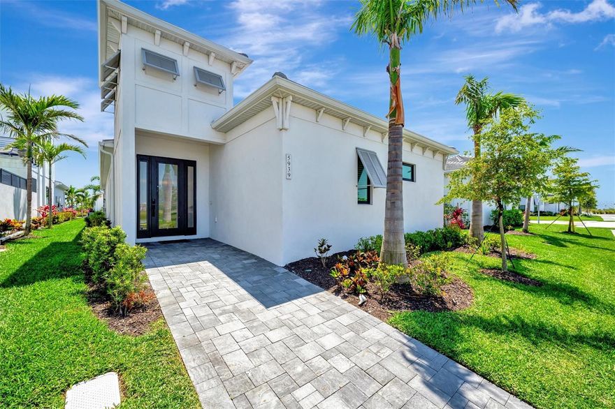 Welcome to your private oasis in one of Bradenton’s most exciting communities, Aqua Lagoon. Perfectly situated near the scenic shores of Sarasota Bay, this neighborhood is centered around a breathtaking four-acre, crystal-clear blue lagoon with a private tropical shoreline—bringing the beach right to your backyard. This stunning 3-bedroom, 2-bath home is located on a premium lot with no home directly in front, offering unobstructed water views from the moment you step through the front entrance. Designed with meticulous attention to detail and nearly $300,000 in luxury upgrades, this home redefines Florida living by blending everyday comfort with high-end finishes and thoughtful design. Inside, the open floor plan is complemented by sleek tile flooring throughout, a spacious living room with tray ceilings, and a striking floor-to-ceiling shiplap accent wall featuring an electric fireplace with color-changing features. Just off the living area, the fully customized chef’s kitchen is a showstopper, showcasing an expanded quartz waterfall island, cast iron farmhouse sink, ceiling-height cabinetry with crown molding, and top-tier appliances including a Sub-Zero refrigerator, Wolf gas cooktop and electric oven, built-in Sharp microwave, and a Décor dishwasher. The kitchen flows seamlessly into a stylish dry bar area with a quartz backsplash that extends to the ceiling, complete with a Sub-Zero ice maker and KitchenAid beverage refrigerator. A custom walk-in pantry with built-in shelving sits adjacent to the bar for added convenience. The home’s heart is the private courtyard—an entertainer’s dream and a tranquil retreat in one. The heated pool and spa combo features a waterfall, jets, and LED lighting to set the mood. A covered lanai with a custom retractable awning provides shade and comfort, with a natural gas hookup already in place for your future outdoor kitchen and grill area. Directly off the courtyard, the spacious primary suite offers tray ceilings, a walk-in closet with custom built-ins, and a luxurious spa-style bathroom with double vanities, an extended walk-in shower with seating, body sprayers, and multiple shower heads. The second bedroom, located at the front of the home, is currently set up as a home office or den, while the third bedroom, with custom closet built-ins, is positioned for privacy and sits next to a beautifully upgraded second full bath. Additional highlights include a fully outfitted laundry room with cabinet storage and an added utility sink, a rear-load two-car garage with paver driveway, epoxy flooring, built-in shelving, and a side service door. The home is wired for AV and security cameras, offering peace of mind and modern convenience. Located just minutes from world-renowned IMG Academy, IMG Golf & Country Club, Anna Maria Island, Cortez Village, and SRQ Airport, this tropical paradise also offers easy access to shopping and entertainment at UTC and St. Armands Circle. Skip the wait for new construction and step into a fully completed, meticulously upgraded retreat that offers resort-style living every single day. Schedule your private showing today!