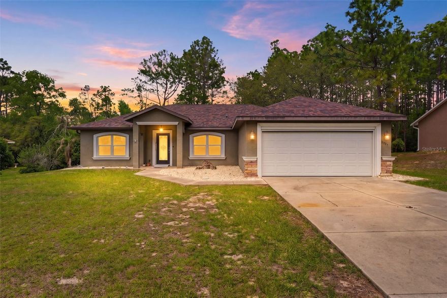 One or more photo(s) has been virtually staged. A welcoming covered porch entry invites you into this thoughtfully designed 3-bedroom, 2-bath, 2 car garage home with a split plan, set on an expansive 0.71-acre homesite, with woods, covered RV carport, additional storage facilities. Inside, the living room immediately draws you in with decorative tile flooring, a beautifully detailed tray ceiling with multiple recessed tiers creates a striking architectural focal point while adding depth and volume to the space, and double glass doors that lead out to the rear covered patio, creating a natural connection between indoor and outdoor living. To the right, the dining area is filled with natural light from a large front-facing window, offering a bright and welcoming space for meals and gatherings, and has matching tile flooring that flows seamlessly throughout the entire home. Just beyond, the kitchen offers a smart layout with both everyday ease and room to gather with granite countertops, solid wood cabinetry, a built-in pantry, breakfast bar, dual sink, and black-finish appliances, all arranged within a layout that keeps everything within easy reach. Adjacent to the kitchen, the breakfast nook provides a cozy setting with a window overlooking the backyard and its own glass door (with blinds built in between the glass panels) access to the patio, making it an ideal spot to start your day. The primary bedroom is spacious and thoughtfully arranged, featuring a tray ceiling, windows with front yard views, a generous walk-in closet with built in shelving and a private en suite bathroom that includes granite countertops, solid wood cabinetry, dual vanities, a wall-to-wall mirror, a private space for the toilet, a window bringing in natural light, and a walk-in shower with grab bar. Bedrooms 2 and 3 are located on the opposite side of the home, each offering ample space (one with built in storage), built-in closets, and windows that bring in soft natural light, with a centrally positioned second bathroom featuring a granite-topped vanity, solid wood under cabinets, and a tub-shower combination. Nearby, the laundry room offers corridor access between the garage and kitchen, and has two sets of upper white cabinets, as well as bottom white cabinets, providing lots of storage space, and is in a centrally placed location to the bedrooms. Step outside to the rear covered patio, where paver flooring and a screened enclosure create a comfortable outdoor retreat overlooking the expansive backyard, offering views of the woods and providing both privacy and room to enjoy the open space in a peaceful setting. The backyard also has a well-maintained storage shed with ramp accessLocated in Citrus Springs, this home is near Rainbow Springs State Park, where clear spring waters and scenic walking trails provide opportunities for swimming, kayaking, and relaxing in nature; Withlacoochee State Trail, a long, paved trail perfect for biking, walking, and enjoying Florida’s natural landscapes; and Crystal River, known for its waterfront views and outdoor activities including boating and fishing, creating a lifestyle that blends everyday comfort with access to the outdoors.