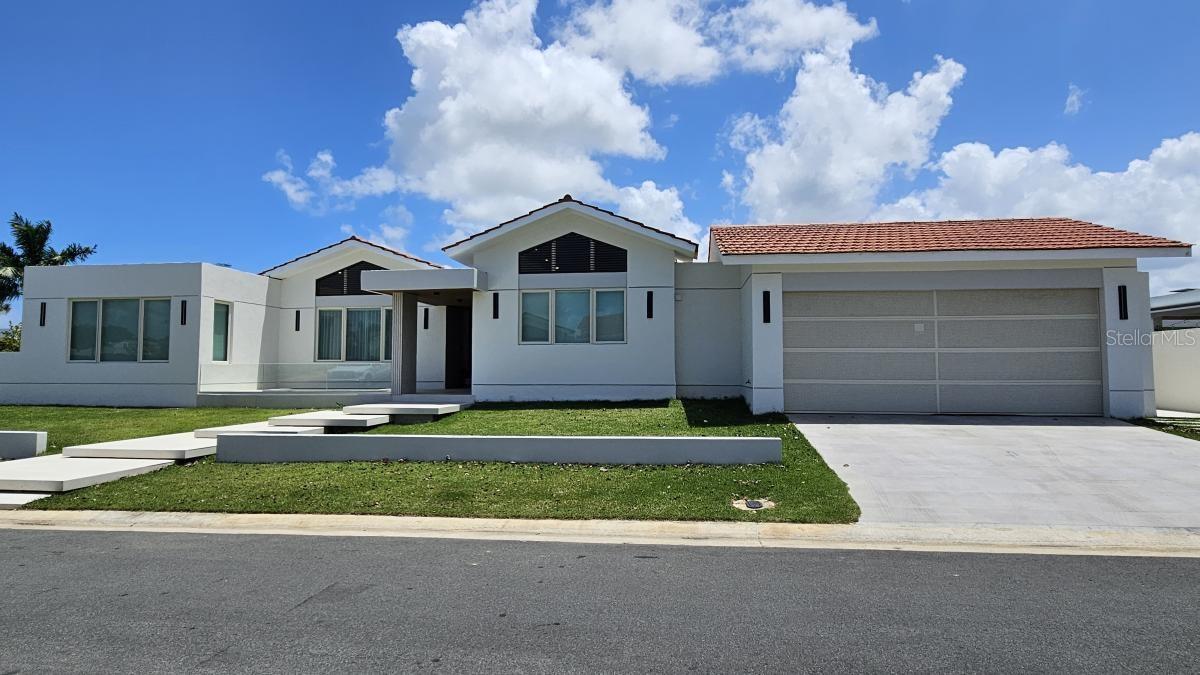 Located in Sabanera Dorado, Puerto Rico, this corner lot with 1,150 square meters of land has a newly constructed and renovated residence that was expanded to 5,800 sf features 5 in suite bedrooms, 5 full bathrooms, and a powder room.
The property features high ceilings and thoughtfully designed living spaces, including a great room, family room, dining area, and outdoor terrace with exquisite tilework throughout. California Closets in all rooms. The design allows for creating an in-law's suite in front of the pool with its own parking and entrance.
The property offers a serene retreat with a sparkling saltwater pool surrounded by lush landscaping. 5 parking spaces plus a golf cart space. Equipped with a 30KW generator, solar water heater, 2,000-gallon cistern and a solar water heater. The kitchen is equipped with Monogram appliances and there are 10 split system air conditioners t