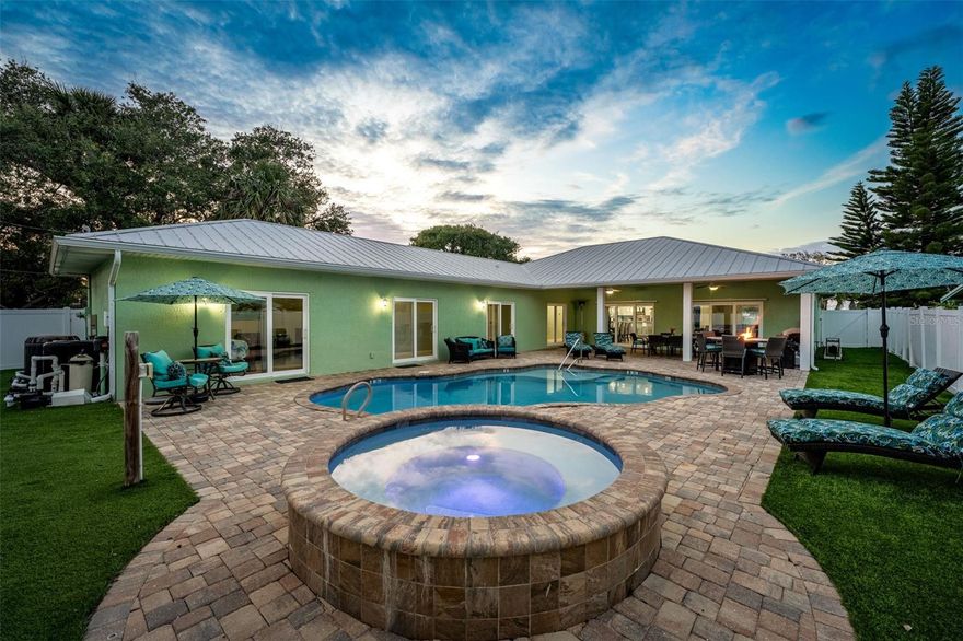 Just two blocks from the beach, this coastal retreat is the definition of smart beachside living. Fully furnished and turn-key, this 4-bed, 4-bath pool home invites guests and owners alike to live and earn in complete comfort. Inside, a bright open floor plan flows seamlessly between the chef's kitchen, dining area, and spacious great room—perfect for entertaining. The kitchen features granite countertops, stainless steel appliances, custom cabinetry, and a breakfast bar as the ideal gathering spot. Each bedroom includes a private ensuite bath, offering space and privacy for guests. Step outside to your private oasis with heated pool and spa, covered lanai, and paver patio for grilling, dining, or relaxing by the fire pit under the stars. Fully equipped, everything conveys—from kitchenware to linens and even a six-passenger golf cart. Whether a primary home, vacation retreat, or high-performing rental, this property delivers lasting coastal value.