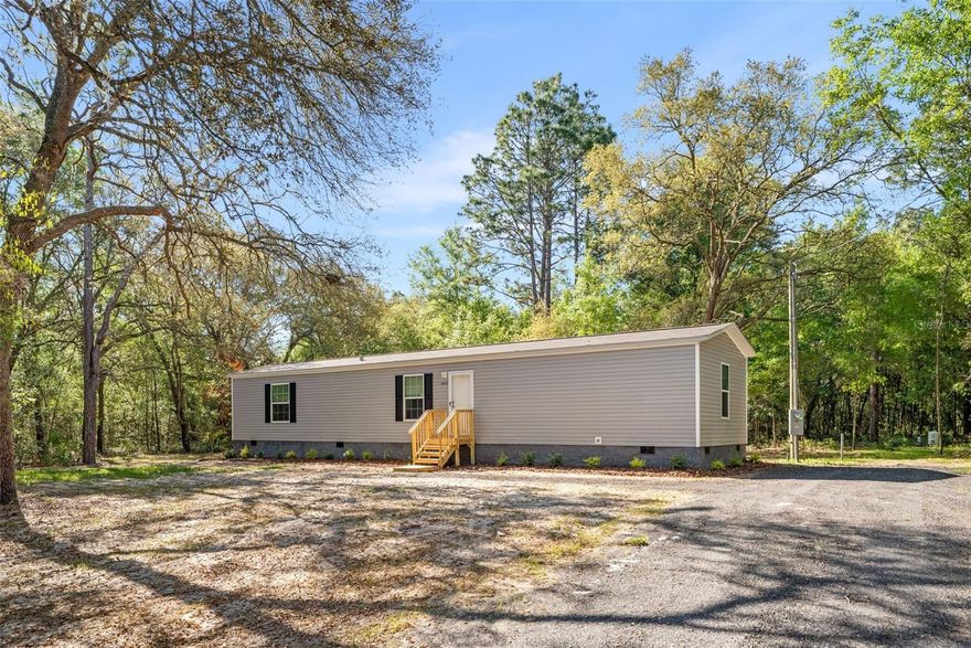 Welcome to the kind of home that checks every box without breaking the bank — a brand-new 3-bedroom, 2-bathroom Champion manufactured home set on 1.25 acres of open Florida land in Bronson. This is turnkey, move-in-ready living where quality construction meets smart design, and every dollar works as hard as you do.

Step inside and you'll notice the difference immediately. The open-concept layout connects the kitchen, dining, and living areas into one bright, airy space that feels bigger than its footprint — designed for real life, not just a floor plan. The split-bedroom layout gives the primary suite its own privacy, away from the secondary bedrooms, so everyone gets the space and quiet they need.

The kitchen comes fully equipped with Whirlpool appliances — range with hood, full-size refrigerator, and dishwasher — plus generous cabinet and counter space for everyday cooking. A Rheem energy-efficient water heater keeps utility costs low, and with Energy Star certification throughout, this home is built to save you money month after month.

Engineered to Wind Zone II standards, this home is built for Florida — That's the kind of quality and peace of mind that comes standard with Champion Homes, one of the nation's leading manufactured homebuilders.

Outside, your 1.25-acre homesite gives you room to breathe. A new well and septic system are already in place, the millings driveway is freshly laid, and the low-maintenance landscaping means weekends are yours — not your yard's. Want to add a workshop, garden, RV pad, or future outbuilding? You've got the space.

Bronson puts you just minutes from Gainesville for shopping, dining, healthcare, and the University of Florida — with none of the city price tag. And when it's time to unwind, you're a short drive from Devil's Den Spring, Goethe State Forest, and Black Prong Resort. This is North Florida living at its finest: peaceful, affordable, and connected.

A one-year home warranty is included for complete peace of mind.

This home won't wait. Schedule your private showing today and see what smart, new-construction living looks like on land you can actually use.