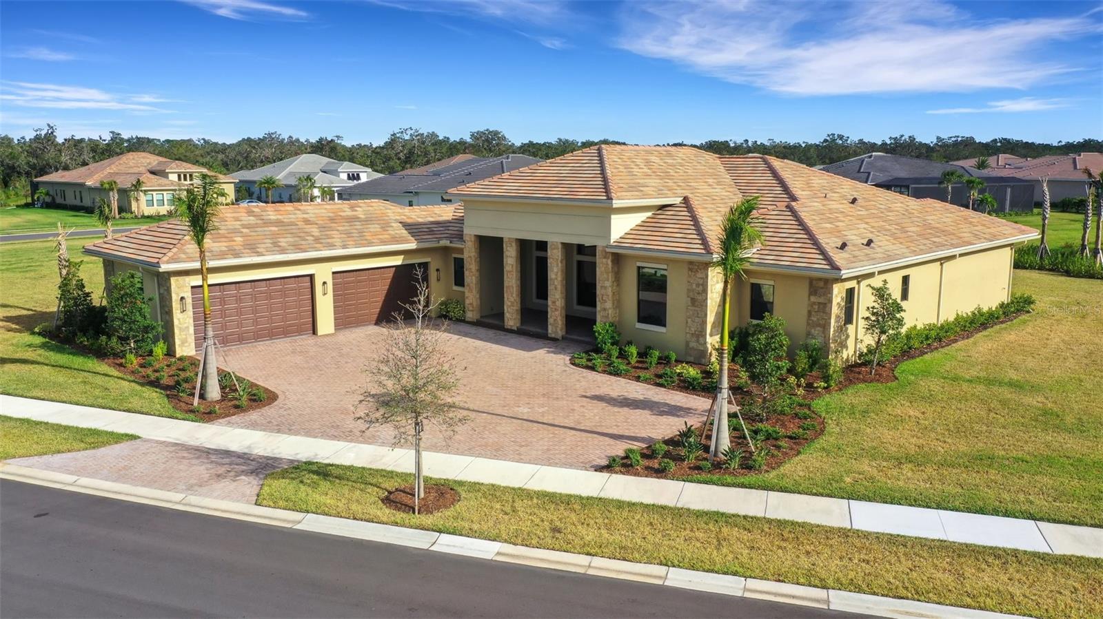 One or more photo(s) has been virtually staged. NEW CONSTRUCTION! Best opportunity in Artistry! Tremendous value! Loaded with upgrades! Indulge in a life of luxury, style, and comfort in this stunning, NEWER BUILT Kolter-built home, NEVER LIVED IN, located in the desirable gated community of Artistry. Set on a spacious over half-acre corner lot, this breathtaking 3-bedroom, 4.5-bathroom home with a den and bonus room offers over 4,063 square feet of living space. The oversized 4+ car garage adds a touch of convenience and grandeur. A striking lead glass double door entry welcomes you into this masterpiece, where soaring 12 to 14-foot tray ceilings create an expansive and dramatic atmosphere. The luxury vinyl plank flooring throughout adds both elegance and durability. Every detail of this home has been carefully chosen, from the sophisticated upgrades to the thoughtful design. The chef’s kitchen is a culinary dream, featuring gleaming quartz countertops and backsplash, 42" dark wood cabinets with crown molding, high-end GE Café stainless steel appliances, a 5-burner natural gas stove, built-in oven with microwave and convection oven, and a large center island with a breakfast bar. Soft-close cabinets and drawers complete this beautifully functional space. Enjoy gathering in the expansive living areas, from the formal living and dining rooms to the open family room. This versatile floor plan includes a bonus room that could easily serve as a 4th bedroom, office, home gym, or playroom. This is the quintessential home for entertaining. Impact-resistant sliders open to two covered paver patios where you can unwind and enjoy serene pond views. The oversized lot offers ample space to add a pool or extend a screened lanai. The split floor plan ensures solitude, with the master retreat on one side of the home and the two en-suite bedrooms on the other. The luxurious primary suite features two large walk-in closets, a spa-like master bath with a garden tub, split vanities, a walk-in shower with intricate tile work, and a frameless glass enclosure. Additional highlights of this home include hurricane-resistant double-pane insulated impact windows, pre-plumbed for gas/electric/plumbing for a future outdoor kitchen and/or pool, security system, sprinkler system, gutters, foam attic insulation, epoxy-coated garage floor, and more! Living in Artistry places you in a prime Sarasota location, close to golf courses, theaters, parks, boating, shopping, dining, and just a short drive from the world-renowned white sand beaches of the Suncoast. This amenity rich community offers lawn and irrigation maintenance, a resort-style pool, a state-of-the-art fitness center, pickleball courts, basketball, playground, and walking trails. Embrace the lifestyle you’ve always dreamed of and make this extraordinary home yours. You won’t be disappointed!