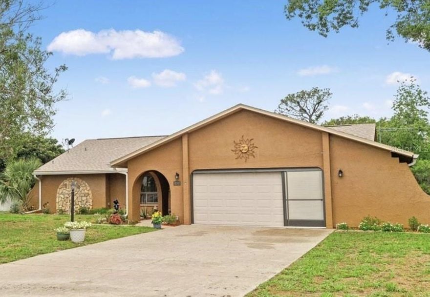 Rare half-acre lot in Spring Hill, solid pool home with outdoor space, layout, and lifestyle buyers desire. No rear neighbors, large partially fenced backyard for privacy, peaceful afternoons by the pool or entertaining under the covered lanai—complete with kitchenette. Two living areas, including a family room off the kitchen, centered around a wood-burning fireplace. Kitchen with eat-in area and views of pool and backyard, blending indoor and outdoor living.