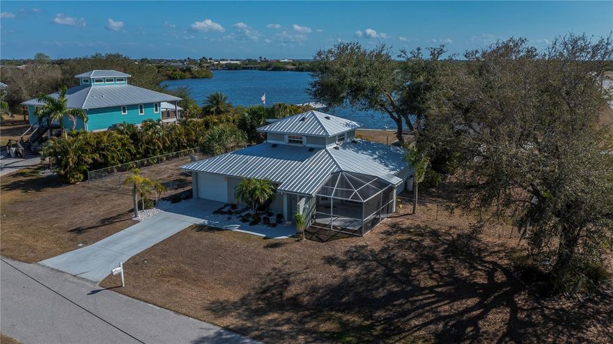 EXPERIENCE SERENE LAKESIDE LIVING in this custom-built 3-bedroom, 2-bath KEY WEST STYLE HOME nestled on a much OVERSIZED CORNER LOT with mesmerizing panoramic saltwater lake views. Located aside the sought-after and newly built Springview Estates, this residence offers unmatched privacy and tranquility with its STATELY METAL ROOF and extra-long driveway situated above a QUIET CUL-DE-SAC.

Step inside to discover an inviting kitchen featuring GRANITE COUNTER TOPS, tile backsplash, under-cabinet lighting, and planter shelves. Sliding doors open to a screened lanai complete with a built-in jetted jacuzzi and a pop-up table after pocketing the sliding doors—perfect for relaxing lunches with LAKE BREEZES and MAGICAL VIEWS including Spring Lake Park... easy use of its nearby boardwalks and public boat ramp. 

The spacious living room boasts vaulted ceilings, abundant natural light, and charming decorator accent shelving, flowing seamlessly into a separate dining area ideal for entertaining. The serene and spacious primary suite offers private back patio access, dual walk-in closets and a full en-suite bath with 2 sinks and an HUGE shower. The second bedroom includes sliding doors direct to the front screened patio, a ceiling fan, and plant accent shelves adjacent to the second bathroom shared with the rest of the home .

Upstairs, the expansive third bedroom is truly your private retreat, complete with premium panoramic water views, french doors to a cozy unshared screened balcony porch, with wood-burning stove—perfect for unwinding and enjoying quiet moments especially dynamic under the starry nights.

Outside, the gigantic FENCED BACK YARD provides a safe, lush oasis with tropical palms and mature oak trees—ideal for pets to roam freely and play safely. Expand with extra area for adding to garage /carport or side driveway. With close proximity to Meadow Park School and the community’s recreational amenities, this home perfectly blends peaceful lakeside charm with convenient living and patio access from every single room, a unique experience! Located close to Port Charlotte Beach which is a favorite biking area, with boat ramp, heated pool, both bocce ball and horseshoe pits, tennis courts, volleyball, playground, boardwalk, fishing pier, pavilions, picnic areas and recreation center, dog friendly and INCREDIBLE SUNSETS! Close to historic downtown Punta Gorda, sunseeeker resort, dining, farmers markets, festivals, PG Airport, shopping and more. 

Don’t miss your chance to own this eye-catching home where most every room offers stunning saltwater lake views, patios and a lifestyle of relaxation. Needs some updates and TLC  and priced accordingly, ready for you to make this one shine even brighter! Schedule your private tour today!