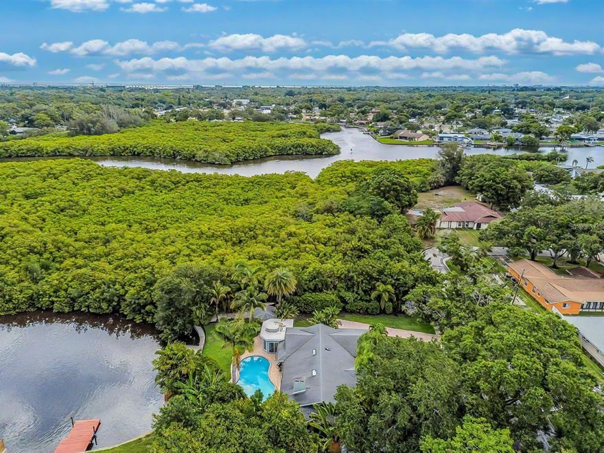 One or more photo(s) have been virtually staged. A RARE chance to own a private waterfront retreat with million-dollar views from every room. This beautiful 3-bedroom, 2-bathroom Frank Lloyd Wright-inspired home includes a 2-car garage and a bonus guest cottage. Located on a quiet, rarely available waterfront lot, the property has just been upgraded with a full renovation, including a brand-new roof, new luxury flooring, a fully remodeled kitchen, updated systems, new landscaping, and more. Designed for true Florida living, the home features floor-to-ceiling windows that fill the space with light and showcase stunning views of the Intracoastal Waterway. Enjoy fishing or watch dolphins, manatees, and birds from your private dock, which has both electric and water hookups and offers direct access to Tampa Bay and the Gulf of Mexico. The chef’s kitchen includes granite counters, high-end stainless steel appliances, solid wood cabinets, a matching island, and a large breakfast bar with views of the pool and water. It flows into the family room, dining area, and cozy living room with a fireplace, perfect for both relaxing and entertaining. The spacious primary suite has water views, his-and-her closets, and a flexible area for a private office or large walk-in closet. The en-suite bath includes a stone garden tub, slate floors, and dual sinks. Just outside one of the bedrooms is a peaceful backyard seating area, perfect for morning coffee. The backyard also features a private gazebo - ideal for lounging, dining, or simply enjoying the view. The detached guest cottage has a water hookup and air conditioning, making it great for visitors, a home office, or a studio. Only four miles from Clearwater Beach and walking distance to Eagle Lake Park, the home also borders an 85-acre bird and mangrove sanctuary, with no rear or right-side neighbors for added privacy. Enjoy amazing sunrises and sunsets from your backyard oasis. Conveniently located just two miles from US-19, 10 minutes from St. Pete–Clearwater Airport, and 20 minutes from Tampa International, this home is close to top dining, shopping, and entertainment. Don’t miss this unique waterfront home - schedule your private showing today!