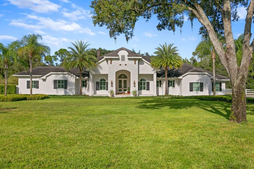 The very best of refined features and privacy are found in this 2015 custom SINGLE STORY Modern Transitional home on 11 acres (5.78 Upland) in Citrus Green, an upscale gated equestrian community designed for the luxury lifestyle. Beautifully appointed and meticulously landscaped, a private gate leads to a gracious floor plan built by Alvarez homes featuring all block construction and Impact windows/doors. Featuring an expansive great room with dual-sided fireplace, dining room and stunning chef’s kitchen with top-of-the-line Thermador appliances, 6-burner professional gas range, and generous center island with quartz countertops. The perfect retreat is found in the private owner’s suite with a double door entry, morning bar, dual walk-in closets and a luxurious bath boasting designer lighting, soaking tub and spacious glass shower. A media room, bonus room with full entertaining bar and 3 additional ensuite bedrooms complete the interior. Enjoy marvelous entertaining areas indoors and out, with large sliders opening to the lanai. Manicured grounds surround the expansive outdoor entertaining area featuring a screen-enclosed saltwater heated pool/spa with sun shelf, fire features, generous covered travertine lanai, multiple gathering areas, fireplace and top of the line outdoor kitchen. From the butterfly garden to a fully fenced yard, tranquil privacy greets you at every turn. Additional features include new lighting, flooring, built in cabinetry, plantation shutters, water purification system, new water heater, full home generator, spacious laundry room, 3 car garage, smart home components, and 10 x 20 free standing out-building with electric. The land adjacent to the home provides opportunity for equestrian facilities, garages or additional outbuildings.