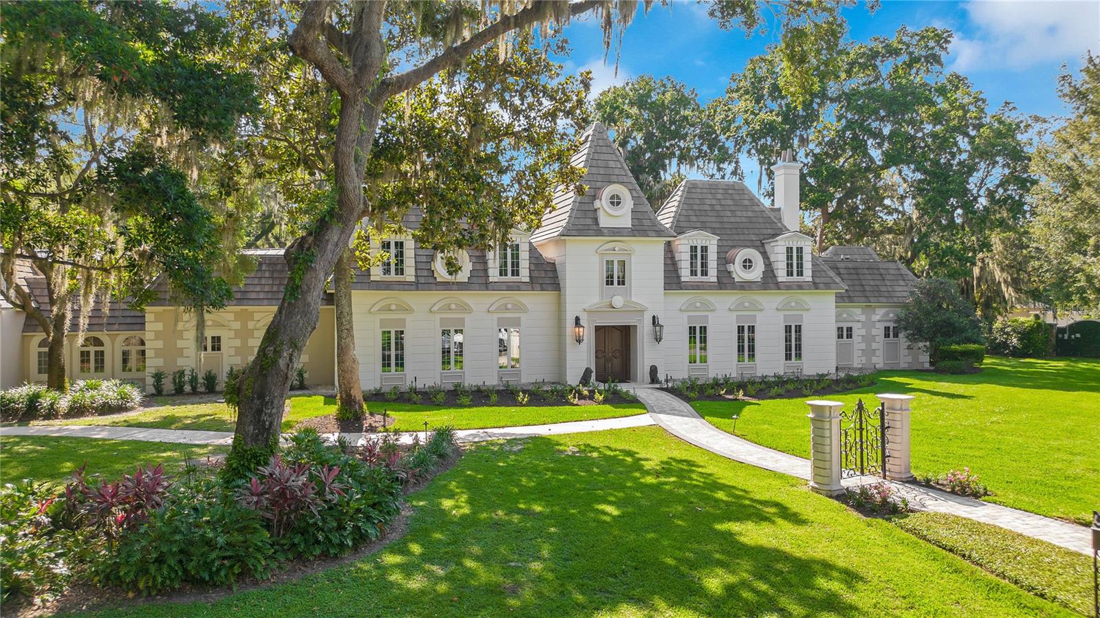 Step into timeless elegance with this extraordinary French Provincial estate, nestled in the highly sought-after gated community of Cranes Point—just minutes south of Downtown Orlando. Inspired by the Château de Cheverny in France’s enchanting Loire Valley, this architectural masterpiece offers an unparalleled blend of European sophistication and Florida lifestyle comfort.
Crafted in 1998 by Capri Homes and designed by renowned architect Herbert L. Banks, this custom-built 5-bedroom, 5-bath residence includes a private 1-bedroom, 1-bath, 787 sq ft garage apartment—ideal for guests, multigenerational living, or a private office retreat. With over 6,200 sq ft of refined living space, every detail reflects quality craftsmanship and timeless design.
The gourmet kitchen is a chef’s delight, equipped with premium Viking and Sub-Zero appliances, a generous center island, and custom cabinetry that blends elegance with function. Adjacent, a butler’s pantry and custom wine room elevate your entertaining experience.
Warmth and charm radiate throughout with four gas fireplaces gracing the primary suite, dining room, kitchen, and family room. The spacious owner’s retreat features new carpeting, built-in bookcases, incredible custom closets, and a spa-like bath complete with a private exercise room and full laundry closet.
Step outside to your own serene sanctuary—majestic oak trees frame the manicured lawn, while a screened-in patio surrounds the heated pool and custom outdoor kitchen with built-in grill, perfect for year-round gatherings.
Additional features include a whole-house gas generator for peace of mind and a concrete tile roof replaced in 2020.
Located just moments from downtown, premier hospitals, cultural attractions, and top shopping destinations, Cranes Point offers privacy, prestige, and convenience in one of Orlando’s most desirable enclaves.
Don’t miss your chance to own this rare French Country estate. Schedule your private showing today.