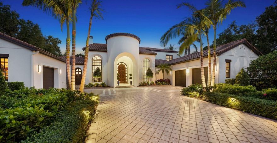 Grand and glorious executive residence with extraordinary details and a simply stunning 6,262 square foot floor plan of luxurious open living. A truly magical experience awaits with eye-catching amenities and magnificent finishes and fixtures that are second to none. Constructed in 2008 by Anchor Home Builders and remodeled in 2019, this 5 ensuite home exudes an air of comfortable elegance and draws you in to explore every nuance from its curved portico entrance with arched entry and gorgeous rounded-top door wrapped in sidelights to the lavish foyer with inlaid flooring and see-thru views to the beautiful outdoor area. The 2-story grand salon greets you with a regal ambiance with its triple set of French doors opening to the pool, lengthy clerestory windows for wonderful natural light, and a fireplace with built-ins on both sides. The divine island kitchen with 12’ ceiling goes above and beyond with top-of-the-line SubZero, Wolf and Bosch appliances and has double-thick granite counters, custom solid wood cabinetry, 2 dishwashers, 6-burner stove with griddle, 48” French door refrigerator, travertine floor, walk-in pantry, built-in desk, breakfast café, butler’s pantry with full wet bar, and even a walk-in wine cellar! The formal dining room has an exquisite 14’ cove ceiling with LED lighting and a 12’ ceiling in the family living room showcases the built-in custom solid wood entertainment center with under-shelf lighting. The secluded primary ensuite encompasses one entire side of the home and includes an office/study with custom cabinetry and LED lighting, 2 desks, and under-counter refrigerator. The primary bedroom features a custom-built bed wall, electronic blackout draperies, triple window alcove for fabulous views, and private door to the lanai and lovely backyard. A private garden setting for the primary bath is one of sublime privacy and pure indulgence with 2 walk-in closets, Jacuzzi tub, multi-head rain shower with sliding doors to the outdoor shower, and 2 custom wood vanities with mother of pearl counters. Also on the first living level are 2 additional ensuites. Adjacent to the pool path is a bonus room located off the outdoor living area. The second floor is highlighted with features like a 4th ensuite, an exercise room (5th bedroom) with sliding door access to the balcony, a billiard room with 4-seat bar with granite counters and SubZero refrigerator with ice maker. Also on this level is an oversized movie theater with built-in surround sound and updated Sony projector. You’ll love the heated saltwater pool and Jacuzzi with PebbleTec, paver decking, pool and updated multi-color LED lights. An outdoor kitchen comes equipped with a gas fireplace, gas grill, refrigerator, TV mount, and 2 Phantom screens with remote control operation. The backyard is fenced for the ultimate in privacy and has mature lush plantings. Additional highlights include a 3-car garage, generator, 3 HVAC units, new wood floors, smart home system, solid core interior doors, laundry with utility sink and storage, powder bath with stone bowl sink, and cypress ceilings on 2nd floor balcony, 1st floor outdoor living, and lanai. Fabulous location just off Orange Ave and across the street from Harbor Acres. Top ranked school system and near all of Sarasota’s sensational pleasures. One of the most spectacular examples of intelligent architecture, artful interior design and quality construction you’ll find. Even the most discerning buyer will be impressed.