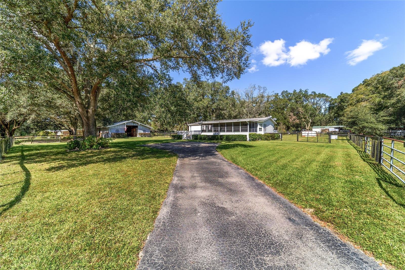 Welcome to this charming 2.29-acre farm nestled in the desirable equestrian community of Thoroughbred Acres, just 2 miles to the World Equestrian Center and 7 miles to I-75—an ideal location for horse lovers and active equestrians. This well-maintained 1999-built two-bedroom, two-bath home offers 1,446 square feet of living space (1,822 total sq ft) and radiates a warm farmhouse feel with freshly painted neutral tones, laminate wood flooring, and rustic wood accents throughout.
From the moment you arrive, the asphalt driveway and designated parking areas make for easy access, while the front screened porch, open front deck, and spacious rear deck offer multiple outdoor living spaces to enjoy peaceful mornings or relaxed evenings overlooking the green pastures. Step inside to an open-concept layout where the living, kitchen, and dining areas flow seamlessly together—perfect for everyday living or casual entertaining. A stunning floor-to-ceiling stacked stone wood-burning fireplace creates a cozy focal point and sliding glass doors on both sides fill the home with natural light while offering direct access to the front and back decks.
The kitchen is generously sized and designed with both style and function in mind. It features a center island with a built-in cooktop, stainless steel appliances, ample cabinet space, two pantries and large windows with picturesque views of the property—ideal for preparing meals while keeping an eye on the horses.
The split bedroom floorplan provides privacy and comfort, with a spacious master suite that includes a walk-in closet and an en-suite featuring double sinks and a large walk-in shower with dual shower heads. The secondary bedroom and guest bath are located on the opposite side, ideal for guests or family. On this side of the home, you will also find the inside laundry room with built in cabinets and plenty of room for extra storage.
Step outside to enjoy lush green grass, tHREE fully fenced paddocks, a wood storage shed, a smaller metal shed and a four-stall wood center aisle barn with a tack/feed room, separate storage area, and a dedicated wash rack—everything you need for a functional horse operation. The property is completely fenced and thoughtfully laid out, allowing for easy turnout and pasture rotation.
Whether you're looking for a weekend equestrian retreat, a manageable hobby farm, or a permanent home close to WEC, this property offers charm, function, and location—all at an approachable scale.