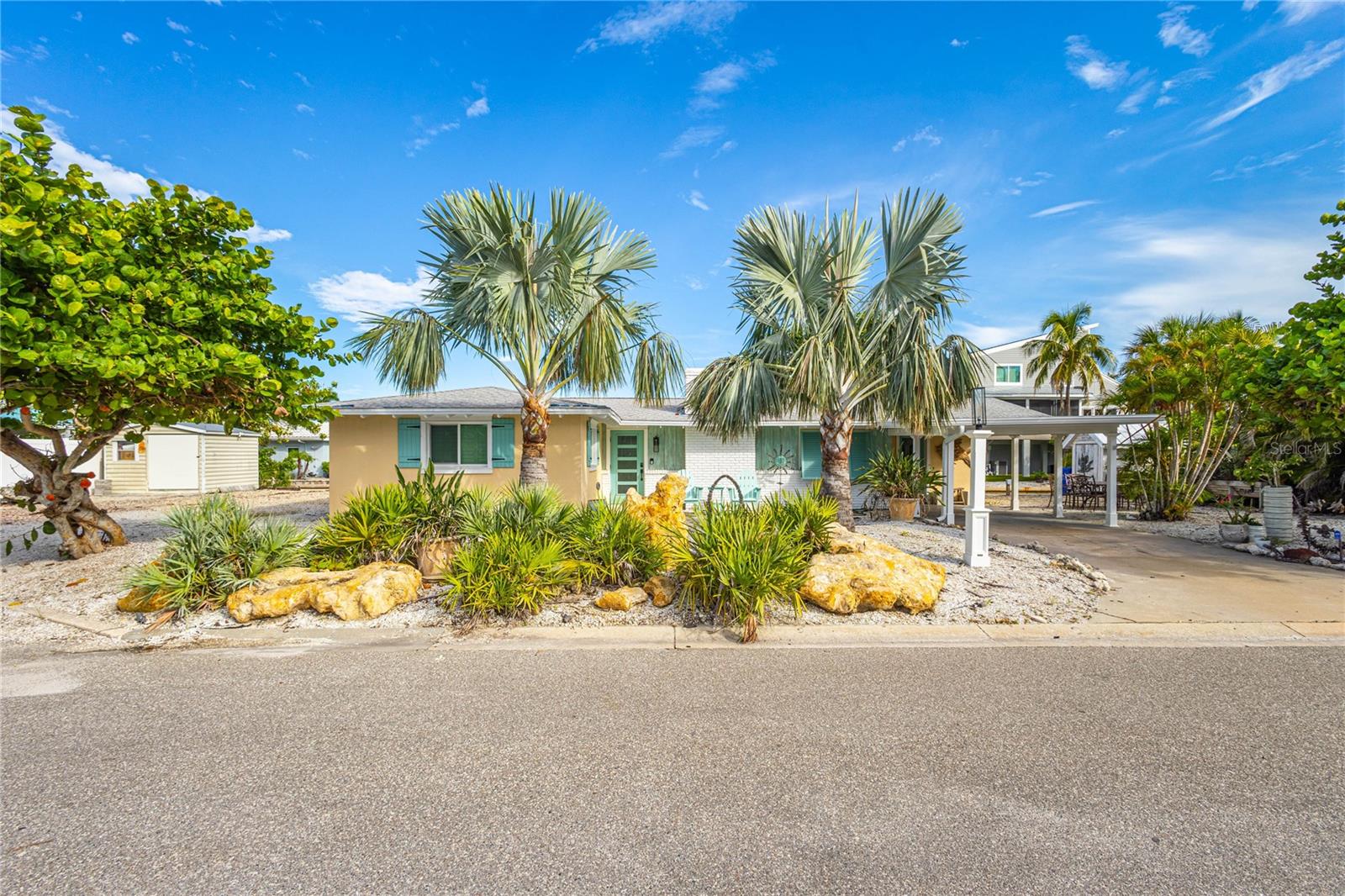 Don't miss the opportunity to build your dream home in one of Longboat Key’s most sought-after, established neighborhoods. Nestled right next to Joan M. Durante Bayfront Park and with beach access across the street you'll have quick access to the pristine, world-renowned Gulf of Mexico beaches. The newly restored seawall (2021) with wide concrete cap and raised dock with nautical dock lights at each pier also features a 10,000 lb lift (elevator type) and is the perfect place to house your boat with quick access to Sarasota Bay and waterways beyond! The lot offers lovely mature trees and plenty of room for a pool. No HOA or CDD. Seller will provide existing house plans from Topsider Homes (any changes to plans would come at the expense of the buyer). Topsider Homes is a luxury builder that offers a design center for picking finishes and is experienced in building in hurricane prone areas. Prefer a renovation project? The existing Old Florida-style 2-bedroom, 1.5-bath ranch home with classic terrazzo floors offers tons of charm and potential. With a bit of vision, it could become a cozy primary residence or an income-producing rental.