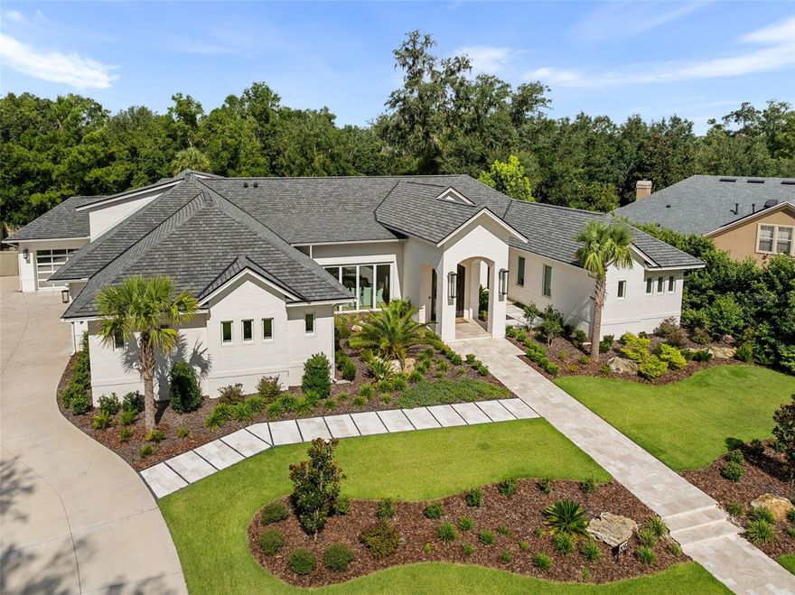 One or more photo(s) has been virtually staged. Experience the pinnacle of luxury living in this stunning, custom-built masterpiece in the highly sought-after Branton Court of Haile Plantation. With an impressive 6,937 sq ft of heated/cooled living space and an additional 572 sq ft of climate-controlled unfinished space, this exceptional residence blends timeless design, modern innovation, and superior craftsmanship. Constructed with energy efficiency and longevity in mind, the home showcases ICF construction, classic brick exterior, and an extended-life roof, delivering both durability and refined curb appeal. Step through grand, custom-forged iron doors into an expansive open-concept layout, bathed in natural light from dramatic, oversized windows that frame views of the lush surroundings. This architectural gem offers 6 generously sized bedrooms, 4 luxurious en-suite full bathrooms, and 2 half baths, all thoughtfully designed with both comfort and elegance in mind. The home’s interior is enhanced by rich, wide-plank wood floors that flow gracefully throughout the main living areas, adding warmth, sophistication, and timeless elegance. This home also includes a rare and fully handicap-accessible private casita with its own spacious bedroom and spa-like en-suite bathroom—ideal for guests, in-laws, or live-in caretakers. The heart of the home is a gourmet chef’s kitchen, equipped with top-of-the-line Wolf and Sub-Zero appliances including an induction cooktop, double ovens, steam oven, warming drawer. Custom Busby cabinetry adds richness and functionality, while the stylish wet bar features a second dishwasher, ice maker, and wine refrigerator. For the ultimate entertaining experience, the residence is equipped with a premium built-in surround sound system, delivering high-fidelity audio throughout key living spaces. Tucked behind the cabinetry, discover a spacious walk-in hidden pantry, offering abundant storage, discreet organization, and a touch of luxury that blends seamlessly with the kitchen’s clean, elevated design. Unwind in the versatile bonus room, ideal for a media lounge, home gym, or playroom. Advanced home technology includes the Moen Flo Smart Water Monitor and Shutoff System, offering 24/7 leak detection and remote water control for ultimate peace of mind. Enjoy a quiet evening under the covered patio with a fully equipped summer kitchen. This expansive outdoor cooking area features a professional-grade grill, flat-top griddle, and generous counter space. Every inch of this estate has been meticulously curated with premium finishes, designer details, and custom features that set it apart. This home offers an unparalleled lifestyle of comfort, sophistication, and lasting value. Don't miss the opportunity to own one of Haile Plantation’s most distinctive and desirable luxury homes.