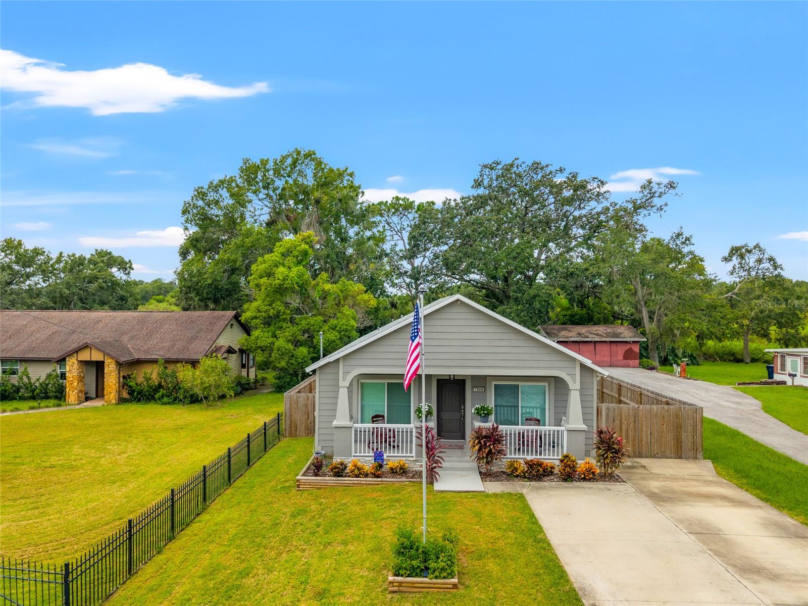 Experience the opportunity to reside on the Hillsborough River in this exceptional riverfront Tampa bungalow, combining comfort, style, and convenience. The property features a telescopic flagpole and a spacious driveway with ample parking for guests, complemented by an inviting front porch. Upon entry, the interior showcases rich wood-style waterproof laminate floors (Oct 2022, $6,000) and impressive vaulted ceilings with adjustable LED recessed lighting, establishing an elegant and relaxing ambiance. The gourmet kitchen offers abundant natural light through a large window and features a refined design that enhances the open floor plan. Highlights include new Samsung appliances—refrigerator, microwave, stove, and dishwasher (Oct. 2022)—white cabinetry and pantry topped with crown molding, subway-style glass tile backsplash, sleek quartz countertops, and deep stainless steel double sinks. The laundry area is equipped with a full-size GE washer and dryer (Jan 2022). This home comprises two primary suites: one spacious bedroom and full bathroom located off the great room behind barn doors, and another suite at the rear of the home features a door with an adjustable shutter between the glass panes that leading to the backyard, a flex room with a custom closet organizer (Jan 2023, $3,200), currently utilized as a temporary office. The flex room offers versatility and can be converted back into a fourth bedroom if desired. The private fenced backyard (Nov 2022, $7,000) is accessible via sliding glass doors from the great room or from the primary suite and provides an ideal space for relaxation, entertaining near the fire pit, or enjoying direct river access via the dock. Additional storage is available in a large lockable TuffShed with electric power.
Security is ensured with Lorex and Ring systems monitoring the property's exterior and dock areas. Further amenities include a new water heater (Oct 2022), updated HVAC system with electronic Honeywell thermostat (June 2024, $6,500), and a custom lockable mailbox. Located conveniently near Busch Gardens, Adventure Island, University of South Florida (USF), USF Health, Moffit Cancer Center/McKinley Campus, major highways, public transportation, and a short drive to University of Tampa, Ybor, Downtown, and the Tampa International Airport; this residence offers superior access to Tampa’s premier attractions and amenities.