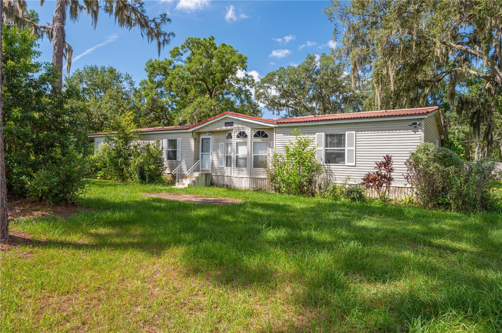 Don't miss this spacious 3 Bedroom, 2.5 Bath manufactured home in Lakeland, FL situated on just under 1 acre! Discover the potential in this home offering over 2,000 square feet of living space just off of Ewell Road. The split floor plan provides privacy, while the heart of the home features a large living/family room with a cozy gas fireplace—perfect for gathering. The kitchen is generously sized with a center island, an abundance of cabinetry, and a walk-in pantry located just off the adjoining utility room with laundry space. A separate dining room adds functionality for entertaining. The master suite boasts an ensuite bath with a walk-in shower, relaxing garden tub, and double vanity. Two additional bedrooms share a hall bath with a shower/tub combo. Ample walk-in closets throughout the home provide plenty of storage. Enjoy the rear enclosed sunroom/porch with walls of windows, ideal for relaxing while overlooking your property. Outside, a storage shed adds even more convenience. Located close to County Line Road and I-4, this home provides easy access for commuters while offering a peaceful setting. With a little TLC, it could be transformed into a fantastic family home or investment opportunity. This property is being sold AS-IS. CASH OFFERS ONLY PLEASE! Schedule your showing today!