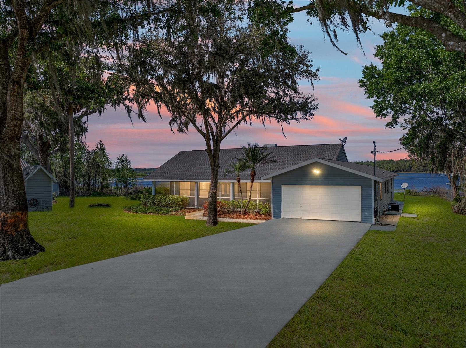 Lakefront living at its finest along the tranquil shore of Dade City's 500-acre Hancock Lake! With 113ft of shoreline and a private dock, this beautifully updated 3 bedroom + office, 3 bath (2 ensuites), 2 car garage pool home has unmatched waterfront views. The home is an entertainer's dream and a peaceful retreat all in one, featuring 2,398 sq. ft. of living space, a sparkling pool and lanai, a brand-new 100ft dock, and a 2020 roof, it is an opportunity that you do not want to miss! Step inside to an expansive 13' x 24' living room with soaring vaulted ceilings, luxury vinyl flooring, and a brick-faced fireplace with a wood mantle- the perfect place to unwind. The dining room, set between the living area and kitchen, features French doors that open to the pool deck, seamlessly blending indoor and outdoor entertaining. The spacious kitchen offers wood cabinetry, stainless steel appliances, a peninsula with breakfast bar seating, and plenty of prep and storage space for the home chef. All 3 bathrooms have been stylishly renovated, complementing the home's generously sized bedrooms. The primary suite is a private retreat with direct pool access, a walk-in closet, and a spa-like ensuite featuring a rectangular soaking tub with serene lake views, a custom walk-in shower with a glass enclosure, and a new vanity. The 2nd bedroom offers its own updated ensuite with a vessel sink and a modern walk-in shower with decorative tile. Finally, the 3rd bedroom, located on the opposite side of the house for privacy, presents beautifully with vaulted ceilings, abundant natural light from four windows, and easy access to the 3rd full bath- which also serves as a convenient pool bath with a trendy tiled walk-in shower and glass-topped vanity. Authentic Florida living awaits outdoors while you swim in the sparkling swimming pool, enjoying the panoramic lake views, or utilize the new 100ft dock that invites you to launch a kayak, fish, or take in the beauty of the private Hancock Lake where no public access is allowed. If you desire more land, the 2.62-acre lot next door is available for purchase separately, offering even more possibilities!! Do not miss your chance to own this incredible lakeside escape. Call today to schedule your private tour!