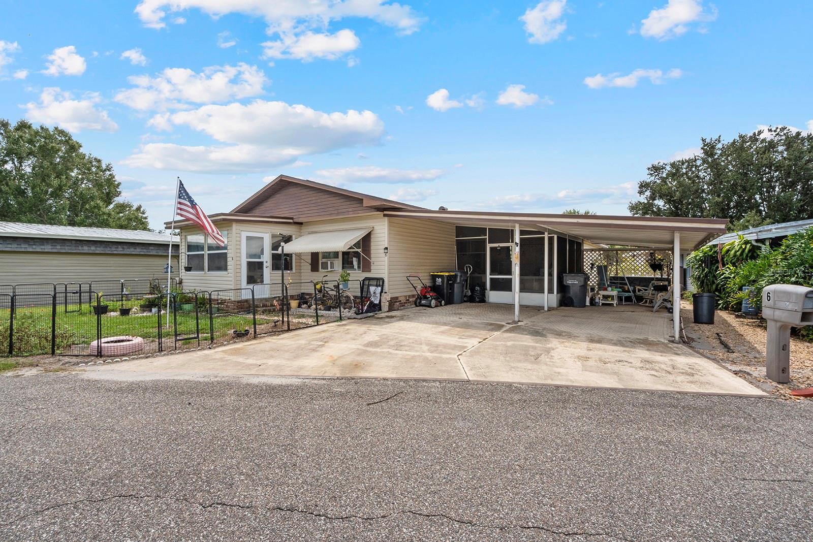 This manufactured home features a 2 bedroom/2 bathroom layout. Built around 1976, this property offers 1,056 sq. ft. The kitchen is equipped with wooden cabinets, a dedicated laundry area for convenience, and vinyl flooring. Both bedrooms include their own bathrooms.
The property includes a triple carport, an attached enclosed 6'×10' glass porch, and utility/storage space. Situated on a lot with large front and back yards, the site is open and not gated.