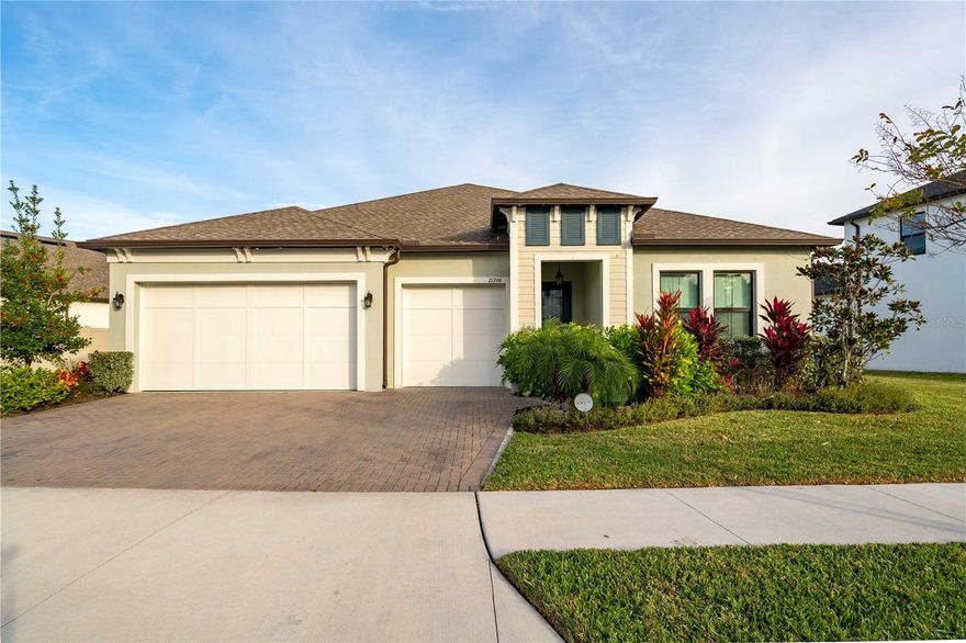 Designed for buyers who want New construction without the wait!! This gorgeous 2022 built residence delivers a rare, move-in-ready opportunity in a gated Land O’ Lakes community just steps from Connerton Elementary. Set on a premium pond-front homesite with no direct rear neighbors, the home offers sweeping water views, privacy, and a serene setting that immediately stands apart.
The interior is bright, open, and architectural, defined by soaring ceiling heights, tray detailing, and crown molding throughout. Natural light pours into the living spaces, amplified by a dramatic three-panel sliding door system that fully opens to a covered paver patio, creating a seamless indoor-outdoor experience and framing the pond beyond. The views become a constant backdrop from the main living area, dining, and primary suite.
At the center of the home, the kitchen is both bold and refined, anchored by an oversized white quartz island and complemented by natural gas cooking. State of the Art appliances. A walk-in pantry with an additional wet bar enhances functionality for entertaining and everyday living, while a built-in bar with wine refrigeration and floating shelving adds a polished, upscale touch.
The home features two primary suites, offering flexibility without compromise. The main primary suite is expansive and tranquil, positioned to capture pond views and natural light, and paired with a spa-inspired bath showcasing a freestanding soaking tub, dual vanities, an oversized glass-enclosed shower, and an impressive walk-in closet. The secondary suite includes its own private bath and walk-in closet, ideal for guests or extended stays.
Additional highlights include a large laundry room with utility sink, a spacious three-car garage with epoxy-finished floors, natural gas water heater and dryer, a newly installed water softener, and brand-new, fully paid solar panels with an approximate $40,000 value that dramatically reduce electric costs. Meticulously maintained and lightly lived in, this home offers modern luxury, energy efficiency, and immediate availability.