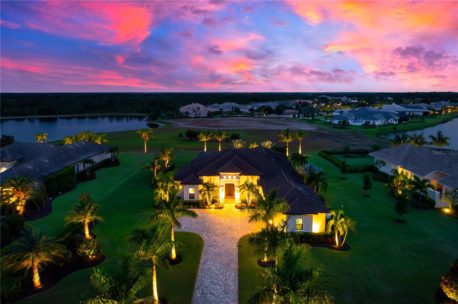 Set amidst 1.15 acres in the exclusive, gated community of The Concession, this custom-built John Cannon home, completed in 2018, offers a lifestyle of unparalleled elegance and comfort. As you arrive, a stately paver driveway framed by royal palms leads you to a three-car side-entry garage, setting the stage for the sophistication within. Inside, 10-foot disappearing glass sliders in the great room create a seamless flow between the indoors and the expansive lanai, where panoramic views of lush landscaping and serene lakes provide the perfect backdrop for unforgettable sunsets. Designed for both relaxation and entertaining, the outdoor oasis features a heated saltwater pool and spa, a gas firepit, and a resort-style kitchen with a high-end grill, sink, and refrigerator.
At the heart of the home is a chef’s kitchen that redefines culinary excellence, boasting Sub-Zero, Wolf, and Bosch appliances, quartz countertops, custom soft-close cabinetry, and a generous kitchen island ideal for gatherings. Adjacent, a bar area with a dual-zone Perlick wine fridge elevates your hosting capabilities. The owner’s suite is a true retreat, featuring dual custom walk-in closets and a spa-inspired bathroom with a freestanding tub, dual vanities, and a glass-enclosed shower with dual showerheads.
Every inch of this home speaks to quality and thoughtful design, with hurricane-rated impact glass, Icynene insulation, a whole-house water softener, and a tankless water heater among its many upgrades. An oversized lot allows for future possibilities, such as a casita or additional garage, ensuring the property can evolve with your vision. Located in The Concession, a community known for its world-class golf course ranked among Florida’s finest and host of the 2021 PGA Workday World Golf Championships, this home is more than a residence—it’s an invitation to live the Florida dream, where sophistication meets serenity. All this is just minutes away from premier shopping, exceptional dining, and scenic bike trails, offering the perfect balance of luxury and convenience.