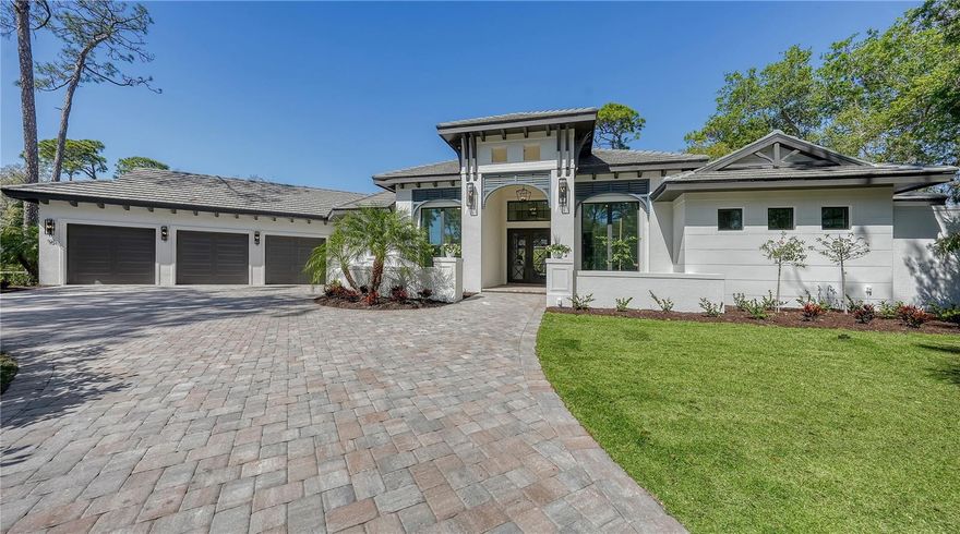New. Notable. No Waiting for your Dream Home!  Rare opportunity for a luxury Florida lifestyle with this just completed John Cannon custom build.  A coveted West of Trail location in The Oaks Bayside positions you in one of the area’s only country club neighborhoods on Sarasota Bay.   With almost 3900sf on one level – and almost a half acre of private grounds – this is no cookie cutter home.  If you crave “one-of-a-kind design” - you’ll delight in the details of this West Indes play on coastal style.  A split plan with 3 ensuite bedrooms, 2 offices and a large den offer the ability to create the space you need – now and in the future. The moment you pass the iron entry doors, you’re instantly drawn to the vaulted ceilings with 7” wood beams and the feeling of freshness and sophistication only a modern design can convey.  Your great room and kitchen transition seamlessly – complete with a linear fireplace and custom bar with wine fridge and ice maker.  Truly a chef’s kitchen, entertain a crowd or intimate group with professional Monogram appliances, French-door oven, gas cooktop, 3 cm quartzite counters with mitered edges, massive island with tv views, butler’s pantry, hidden walk-in pantry, spice drawers, shaker cabinets & marble backsplash.  A separate dining space offers views to the pool and grounds.  No detail was left untouched in the owner’s suite – with an oversized light-filled bedroom with tray ceilings; dual closets that can only be described as massive; and a show-stopper bath with center walk-in shower, over the top soaking tub and TWO private patios for relaxing, reading or soaking up the sun!  Desired but rarely found – a large, nearly half acre lot that offers privacy in a natural setting of mature oaks and native landscape.  You’ll love the ample outdoor space for both sun and shade, ClearVue screen, PebbleTec saltwater pool and spa, custom fire bowls for evening ambiance, travertine pool deck, outdoor kitchen with gas grill, cooktop and storage.  Oversized 3-car garage, circle drive and generator pad site & pre wire.  Don’t forget the details you’d expect in a luxury home – impact windows and doors, porcelain tile floors throughout, 10 & 12 ft ceilings and pocketing sliders, LED lighting with custom fixtures and fans, solid core interior doors, tankless hot water heaters and surround sound speakers.  All this in a nationally recognized club neighborhood offering not one – but TWO 18-hole golf courses, pickleball, 12 har-tru tennis courts, fitness center, community heated pool, children’s programs, on-site bar and dining as well as numerous member groups and activities.  Mere minutes to the beaches, dining, shopping, the Legacy Trail, Pine View School for the Gifted and Historic Spanish Point.  And just a short drive to all things Sarasota – downtown, arts and culture and fine dining.  No waiting for membership and access to golf and all activities!