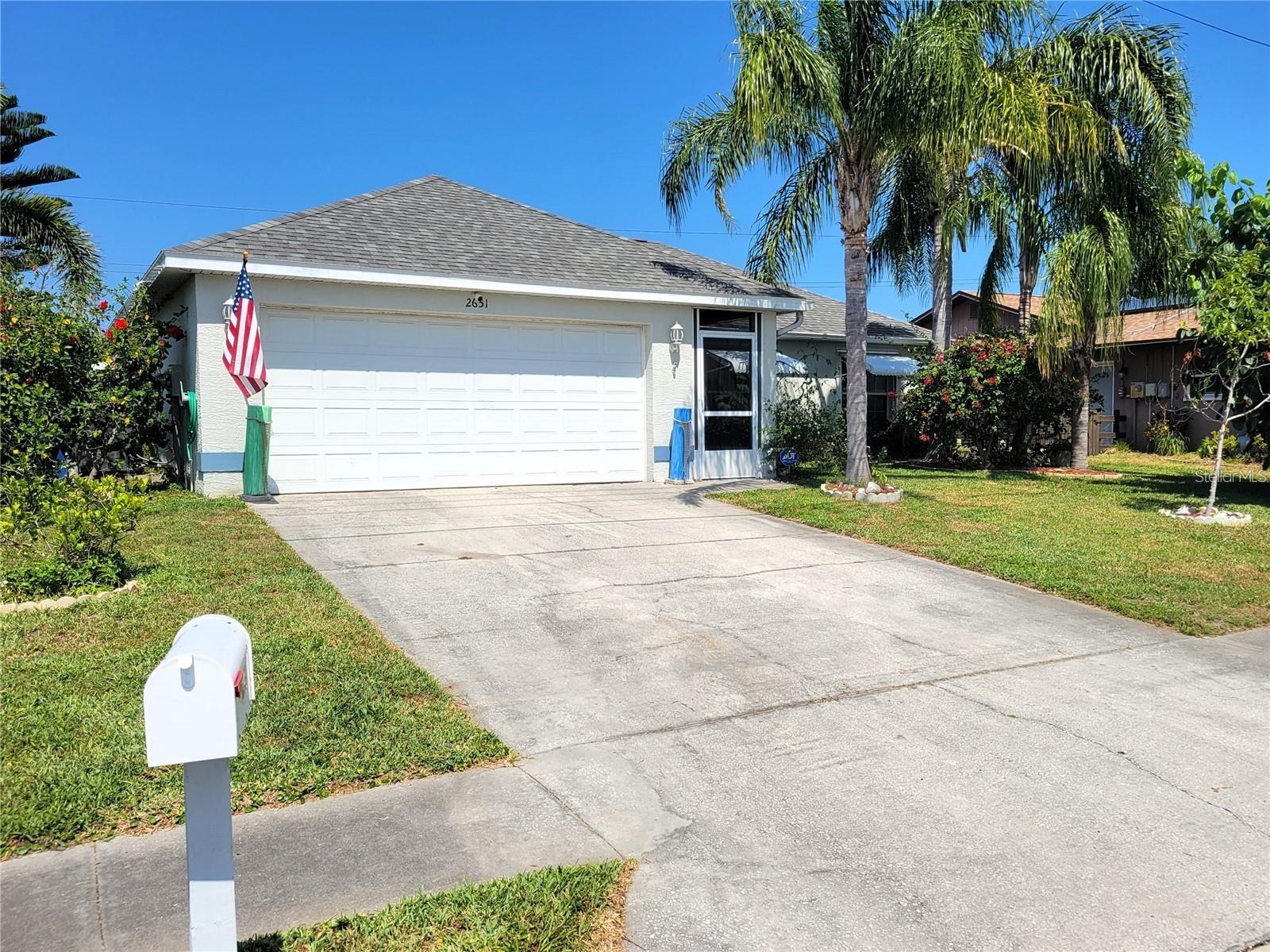Waterfront home with pool, swim spa, and private sandy beach! This 3BR/2BA home with a 2-car garage features an open floor plan filled with natural light. Enjoy a spacious custom deck, private boat dock, and backyard retreat with an above-ground pool, relaxing swim spa, and enclosed patio. The yard is a tropical paradise with papayas, star fruit, grapevines, and a huge mulberry tree out front. Recent updates include a newer roof, A/C, and water heater. Tucked away on a quiet street, this property offers a rare waterfront lifestyle.