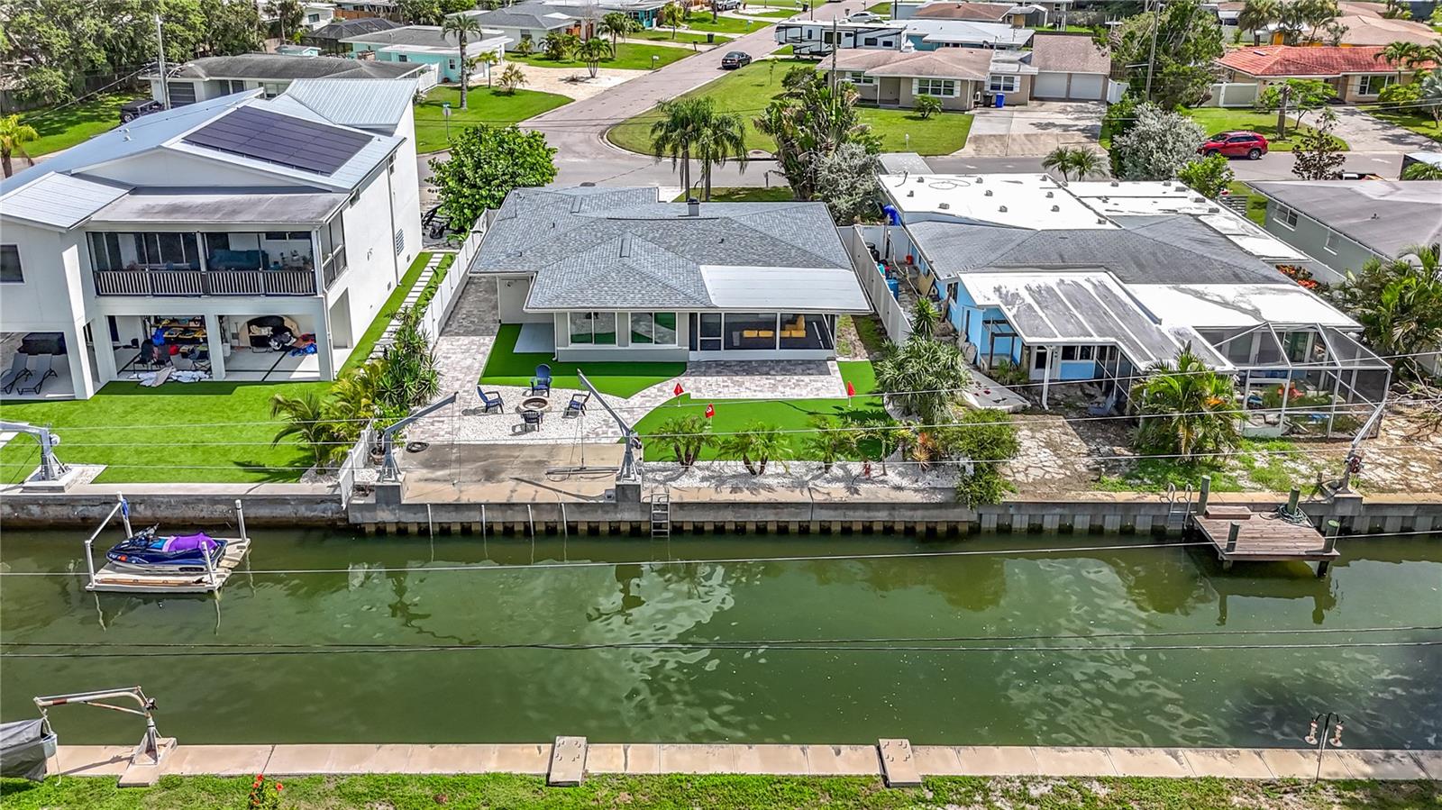 Waterfront living at its finest! This fully renovated home offers direct access to the Intracoastal Waterway with no fixed bridges—ideal for boating and paddleboarding. The open layout features a stunning kitchen with stone quartz countertops, new stainless steel appliances, and elegant 24x48 porcelain floors throughout. Step into your private backyard oasis with a brand-new synthetic turf putting green, a cozy fire pit with seating, and a covered terrace perfect for family gatherings or weekend BBQs. Concrete seawall, davits installed, and plenty of space to enjoy the Florida lifestyle. Located in a quiet cul-de-sac just minutes from Honeymoon Island, the Pinellas Trail, downtown Dunedin, shopping, marinas, and top-rated beaches. Whether you're looking for your forever home, a winter getaway, or a smart investment—this home has it all. Schedule your showing today and experience the charm of coastal living!