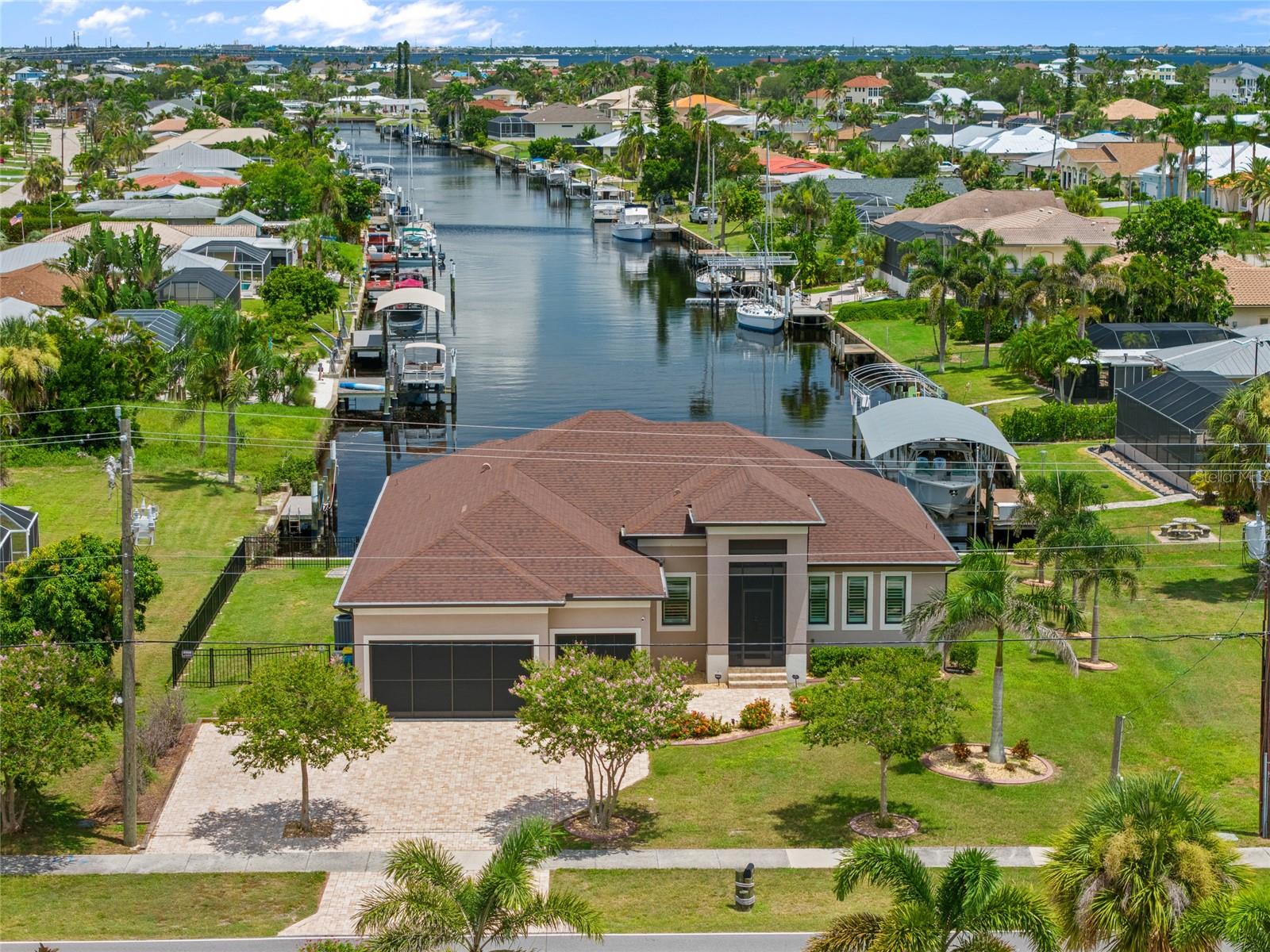 Exceptional 3-bedroom, 2.5-bath, 3-car garage waterfront pool home, built in 2021. Boating enthusiasts will appreciate the quick sailboat access to Charlotte Harbor, leading to the Gulf! Oversized lot offering 120 ft of waterfrontage with an extended 60' composite dock equipped with water and electric, jet ski entry, and a boat lift.
Step inside to discover an open floor plan adorned with contemporary décor and lighting, high ceilings with tray accents, and tile flooring throughout. A chef's dream, the kitchen is equipped with custom cabinetry, granite countertops, a stylish backsplash, stainless appliances, a cooktop with an exhaust hood, and a large breakfast bar perfect for casual dining.
The spacious primary suite is a sanctuary of its own, featuring a pocket slider to the lanai, dual walk-in closets, and a luxurious private bath with dual sinks, a soaking tub, and a Roman shower with spa jets. The junior suite offers a private bath leading directly to the pool, ensuring convenience and privacy for guests.
Indoor-outdoor living is at its finest with a zero slider that seamlessly connects to the covered lanai, showcasing breathtaking long water views. Your private outdoor space includes a screened heated pool and spa with beach entry with southeastern exposure so guests from the north can enjoy an abundance of Florida sunshine.
Additional features include plantation shutters, impact windows, an inside laundry room with Samsung front load washer and dryer, an oversized paver driveway, a generous fenced side yard, perfect for your furry friends to roam and lush tropical landscaping that enhances the home's curb appeal.
Great location close to Port Charlotte Beach Park, Sunseeker Resort, and downtown historic Punta Gorda, you'll enjoy easy access to fine dining, shopping, beautiful parks, award-winning fishing and boating, community events, and entertainment. Don’t miss this opportunity! Schedule your private showing today!