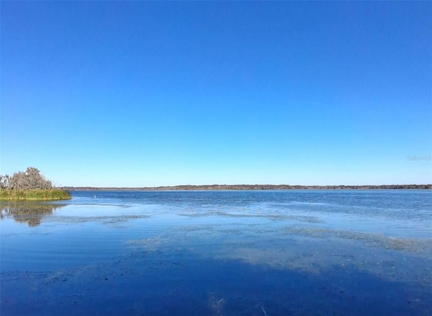 LAKE FRONT with miles of wide open views. You will love the views. Lots of open water and wildlife to enjoy. It's approximately 1 mile directly across the lake. On the other side is Lake Panasoffkee Wildlife Management Area. Lake Panasoffkee is approx 1 mile wide and 5 miles long. The north, south and east sides have lots of marshes and flooded cypress. A large portion of the lake is undeveloped and will remain undeveloped. If you love nature, this lake is for you. Great fishing, lots of birds and other wildlife. From the house you boat down the Outlet River to the Withlacoochee River. Once on the river you can run all day – bring extra gas. Much of the river is gorgeous Old Florida. Not only is the location great, the home is impressive. A family from Tampa used it as there weekend home. They completely redid the home. It's new, new, new and upgraded, upgraded and upgraded. First the layout then I'll list the new.  The home has been expanded from it's original foot print. Formal living and dining room, both with great views of the lake. A large family room on the back of the house and has great view. There's a large screened in porch with all weather windows and window ac that expands your living space – also has a great view.  The main bedroom also has great views. This is a great weekend getaway home, bring lots of friends and family. Two bedrooms and baths are on the north side of the home. Two more bedrooms on the south side. One of those rooms would make a good bunk house for kids, away from the adults. The other bedroom has sliding glass doors out to the lake. It would make a great home office, kids hangout or large 4th bedroom. You have options to make this home fit your lifestyle. The home has gone through a top to bottom renovation with upgrades galore. All NEW nice kitchen cabinets, stone counter tops and NEW upgraded appliances. All the windows have been replaced with double pane hurricane windows. Doors replaced, efficient water heater is NEW, all flooring is NEW, baseboards NEW, chair railing NEW, light fixtures and ceiling fans are all NEW. None of the upgrades are off the shelf cheap Lowe's fix and flip items. The bathroom vanities are very nice, NEW quartz counter tops, NEW soaking tubs, NEW large shower tiles and NEW upgraded toilets. You even get a brand NEW boat dock built a couple months ago. Plus it comes with a drive on floating lift for your boat. Did I mention the metal roof? Wait there's more, The furnishing are optional. This can be your NEW turnkey vacation home, VRBO or Airbnb. For you outdoor sportsmen you have the following WMA's nearby – Lake Pan, Half Moon, Flying Eagle, Citrus, Jumper Creek, Croom and Potts. You have the Villages nearby for restaurants and entertainment. This is an incredible value. You are getting remodeled waterfront home on a big lake for under $500,000. That's a DEAL.