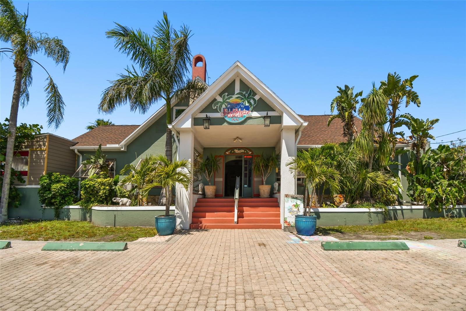 "Welcome to your dream investment opportunity on the Bay in Gulfport, Florida!
Built in 1923, this Tutor Style seven-suite bed and breakfast, complete with a fully operating cafe, offers stunning waterfront views and endless potential. Maintaining much of its historical charm combined with new modern conveniences, this property is a true gem. Enter through the original home's living room with a wood-burning fireplace, where guests can meet and socialize in an inviting, cozy atmosphere. As all the suites are very large with sitting areas and large private baths, the two suites in the main house, first floor are the Aruba Suite with 1.5 private baths overlooking the park and water and the Barbados Suite with a private balcony overlooking the tropical gardens and patio.
The grand staircase will take you to the 3 upstairs suites in the Main house such as the Jamaica Deluxe Suite with a spectacular panoramic view of the bay, private wrap around balcony and 14’ vaulted ceilings. The Bermuda Deluxe Suite, also with vaulted ceiling, features a beautiful private balcony with a prime view of the tropical garden and Boca Ciega Bay. While the Belize is the perfect, private get away suite to round out the 2nd floor.
The two additional cottages off the courtyard both are life in paradise with the 11’ vaulted ceilings and views of the water and beautiful tropical courtyard.
The Breeze Waterfront Café is a key addition to The Inn where guests can dine on the elevated covered porch overlooking the park and Boca Ciega Bay or on the tropical courtyard adding to its allure and relaxing, serene atmosphere.
With immediate income and cash flow, due to the success of both the inn and the café combined with its prime location just blocks away from Gulfport's bustling restaurants and shops, this property is a turnkey operation.
Recent upgrades including a new roof, soffits, facias, windows, doors, and AC units, along with a commercial kitchen boasting a new grease trap and hood system, ensure the property is in top condition. Perfect for weddings and events, the waterfront location provides a picturesque backdrop, while expansion possibilities offer even more potential for growth. Don't miss your chance to own a piece of Gulfport's waterfront charm and hospitality!
