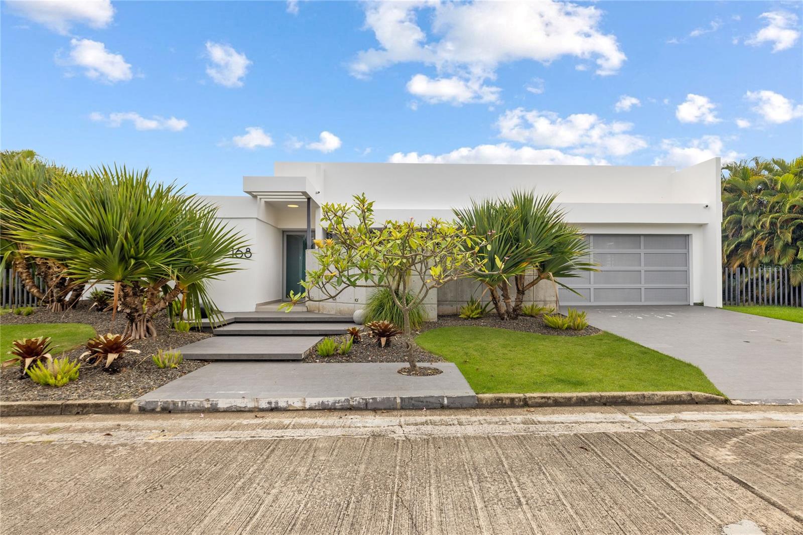 Welcome to this architectural masterpiece located in the exclusive gated community of La Villa de Torrimar in Guaynabo. This fully remodeled, turnkey home seamlessly blends modern elegance with refined design, offering the ultimate lifestyle in one of Puerto Rico’s most sought-after neighborhoods. Situated on a 1,110.63 m² lot, this contemporary residence spans 3,499 sq ft and features an impressive outdoor oasis perfect for entertaining. Enjoy a covered terrace, stunning pool, and a beautiful garden. The interior showcases an open-concept layout with exquisite finishes throughout, featuring a spacious living room, elegant dining area, inviting family room, an impressive designer kitchen with top-of-the-line appliances. For your convenience the house also offers two powder rooms, a well-appointed laundry room, pantry area, garage for two cars and four generously sized bedrooms, and three full bathrooms.
The luxurious primary suite offers resort-style comfort with a private spa bathroom featuring dual shower, an outdoor shower and a dressing room. A junior suite includes its own ensuite bathroom, while the additional bedrooms share a full bath.
Additional features include:
• Solar System: 66 Solar Panels + 5 Tesla Powerwall Batteries
• 600-gallon Water Cistern +16k generator
• Pool Water Heater + Solar Water Heater
• 2 Central A/C Units and 6 A/C Split Units + Washer & Dryer
• Car electric Charger
• Refrigerator, dishwasher, oven, microwave, stove top
• Builts-in
• Lamps and Curtains
• Impact-Resistant Security Doors and Window
Community Amenities:
Residents of La Villa de Torrimar enjoy a range of top-tier amenities: 24/7 security, fitness room, activity room, beach tennis courts, basketball, tennis courts, volleyball courts and playground area. Conveniently located close to private schools, shopping centers and other places of interest.
Don’t miss this rare opportunity to own a designer home in one of Guaynabo’s premier communities. Call today to schedule your private showing!