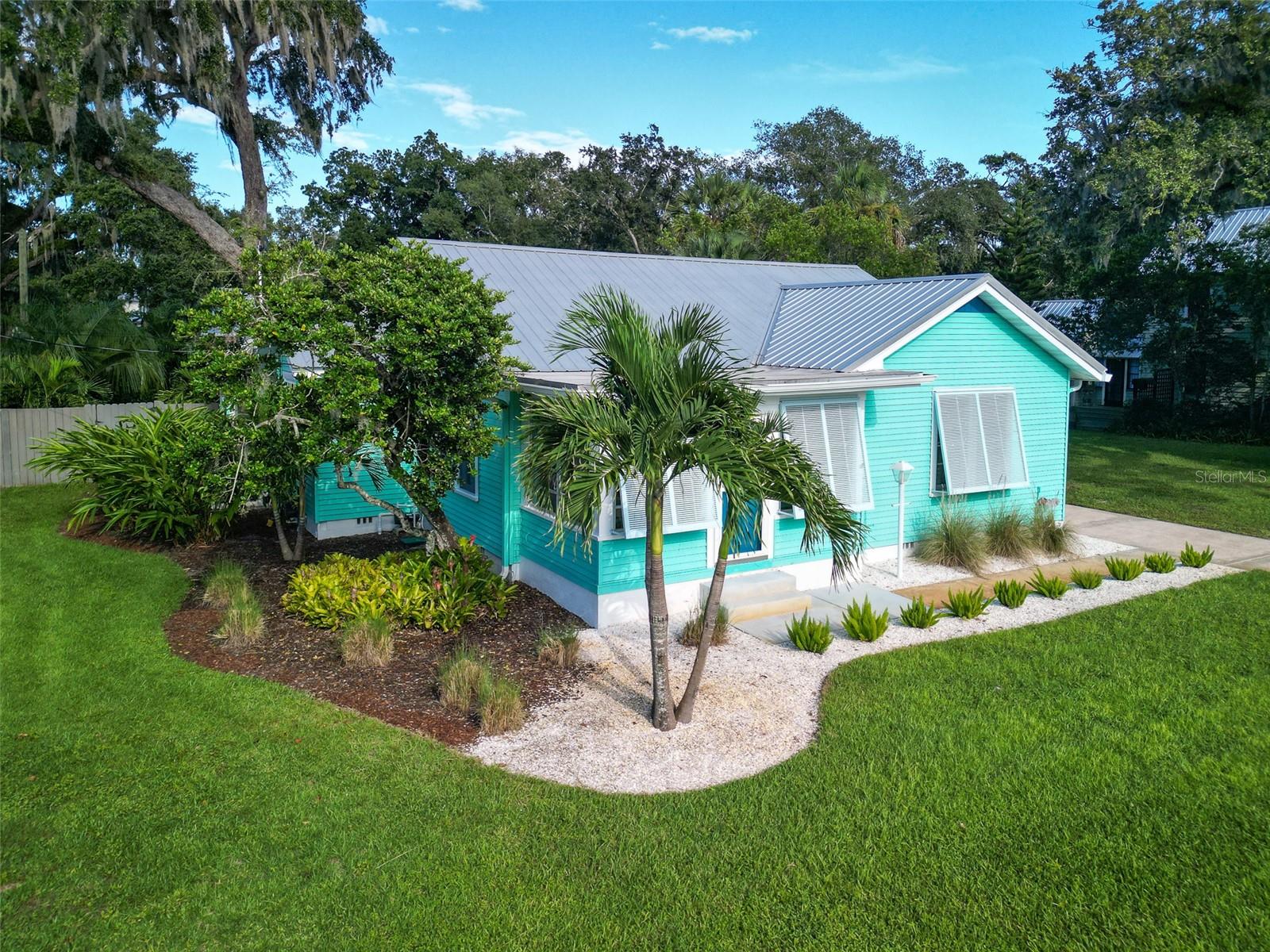 Downtown New Smyrna Beach gem featuring 3 bedrooms, 3.5 baths a private pool and guest quarters. Don’t miss the opportunity to own this truly unique property, ideally situated on a charming corner lot just half a mile from vibrant Canal Street shops, restaurants, and events. Step onto the sunny front porch and into the original 1939 home, where vintage charm meets thoughtful modern updates. The main residence features 2 bedrooms and 2 full baths, with pristine wood flooring in the living room, dining room, and bedrooms. A bright and functional kitchen flows into a spacious family room and utility area, all overlooking the lush, secluded backyard. Tucked away behind tropical landscaping and privacy fencing, the backyard is a private oasis—perfect for entertaining or enjoying quiet solitude. The recently completed 968 square foot guest house includes a private bedroom and bath en-suite, soaring ceilings, a convenient kitchenette, a half bath, and an expansive screen-enclosed lanai with automated shutters. It offers ideal space for in-laws, a home office, or your personal retreat. Enjoy a resort-like lifestyle with expansive travertine decking and a recently built 28.5 x 9.3 pool and separate spa (both utilizing a state-of-the-art UV sanitizing system). An outdoor shower makes cleanup easy after a day at the beach or nearby boat launch just 1 mile away! Flagler Avenue is only 1.5 miles from your door and the beach another half mile further. The home’s sustainability features are equally impressive. The fully paid-for solar system installed in 2022 powers 100 percent of the electric bill. The owner pays a nominal $8.25 monthly base utility rate and receives rebate checks from NSBUC. Well for irrigation. Additional upgrades include -- Two new HVAC systems (2023), Two new tankless gas water heaters (2023). Roofs replaced in 2017 (main house) and 2022 (guest house). There are separate heat pumps for both the pool and spa and the spa is electric heated. Please exclude the dining room light fixture. . This one-of-a-kind property blends comfort, efficiency, and versatility in a prime location. Whether you're hosting guests, working from home, or simply relaxing in your private paradise, this home is ready to welcome you.