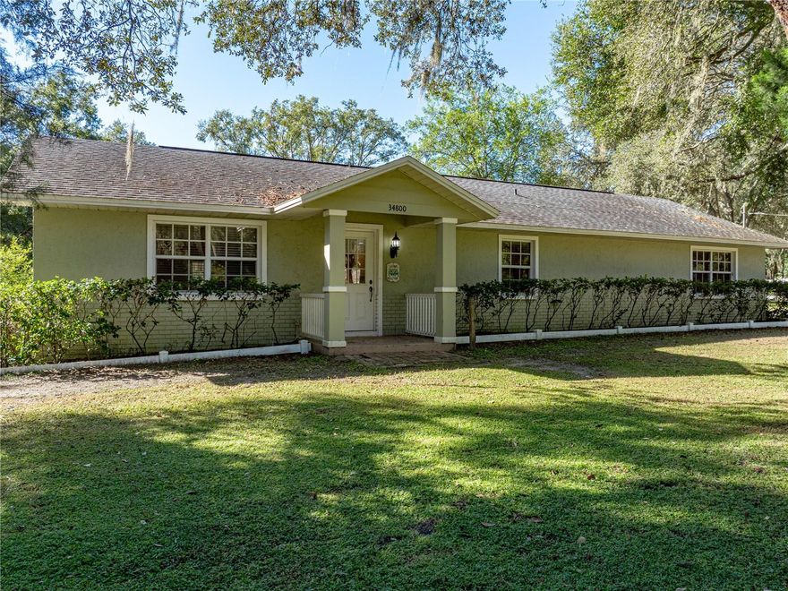Peacefully situated on 2.75 scenic acres in rural Dade City, this property offers the best of
Florida country living with room to spread out and space for every dream to take shape. Arrive to
a picturesque, tree-lined street and a fully fenced and gated property featuring a 3 bedroom, 2
bath, 1,560 sq ft home, an 800 sq ft additional building, a storage shed, and an open-air storage
building, an ideal setup for those seeking a haven away from the hustle and bustle. Inside the
main home, a flexible floor plan opens with a spacious 15x18 family room that flows into a
formal sitting area, providing multiple options for gathering or entertaining. The dining room
features French doors leading out to the screened porch, seamlessly blending indoor and outdoor
living. A custom modern-rustic kitchen is the heart of the home with rich wood cabinetry, granite
countertops, stainless steel appliances, and convenient pantry storage. The 18x12 primary suite
offers generous sleeping quarters, a built-in closet, and a private ensuite bathroom with a walk-in
shower. Bedroom 2 is tucked into a cozy guest nook with an oversized walk-in closet, perfectly
positioned near the third bedroom and the updated hall bath featuring a tub/shower combo. Step
outside to the screened porch and take in the tranquil landscape, sunlight filtering through mature
trees, open green space for recreation or relaxation, and a true sense of privacy that’s hard to find.
With AR zoning, the property is ready for your agricultural ambitions, bring your animals, plant
a garden, or simply enjoy the peaceful surroundings. The 800 sq ft second building expands the
possibilities, complete with a full bathroom, kitchen, two large closets, and an 18x30 workshop
area. Here, rural tranquility meets convenience, just minutes from downtown Dade City’s
charming shops, dining, and festivals, and a quick drive to major highways for easy access to
Tampa, Orlando, or Florida’s Gulf Coast beaches. Embrace the best of both worlds and make this
versatile Florida retreat your own!