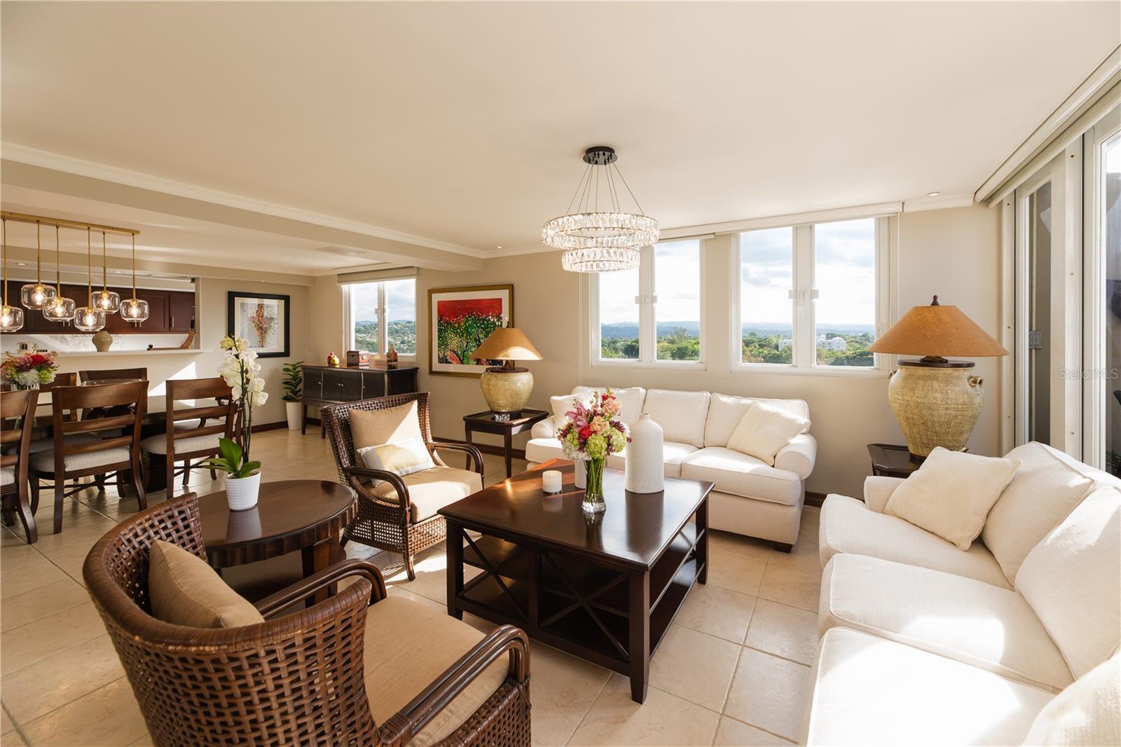 Beautiful, fully furnished and equipped penthouse apartment featuring 2,145 SF of interior space and a 540 SF terrace facing PR-2, with panoramic views of San Juan, Cataño, Guaynabo, and Bayamón. The apartment includes an entrance foyer, a spacious kitchen, a dining area with an 8-seat table, a family room with sofas and a center table, a living room with a plasma TV, and two generously sized bedrooms—each with its own walk-in closet and full bathroom—as well as a laundry room. Thoughtfully decorated with unique and beautiful artwork, this home is in mint condition. Two covered parking stalls are conveniently located near the entrance to the elevator lobby. Building amenities include a pool, gym, visitor parking, full backup power generator, water cistern, and an air-conditioned lobby. Offered in completely move-in-ready condition with high-end finishes and furniture.