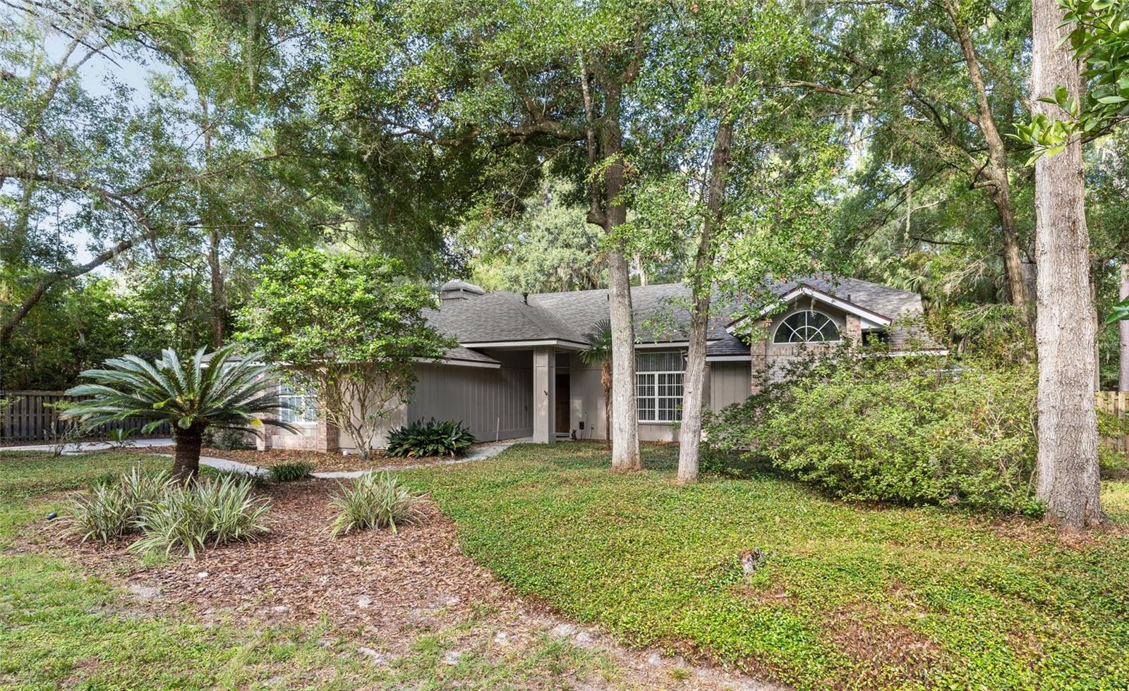 Welcome to Huntington - Gainesville's Best Kept Secret Neighborhood!
Nestled among gorgeous mossy oaks and ivy ground cover that epitomes the OLD FLORIDA FEEL everyone loves, this four-bedroom, two-bath executive-style POOL home on almost a half-acre lot is ready for its new owners to make their own. With 2,447 sq. ft. of living space, a split floor plan, and a gorgeous salt-water pool plus lanai, this home is designed with both comfort and entertaining in mind. Step inside and you will find two spacious living areas, including a cozy den just off the kitchen with gas fireplace for inclusive, open concept living. The chef’s kitchen boasts a gas stainless steel stove, stainless appliances, wood cabinetry, granite countertops, and a large breakfast bar—perfect for casual dining or gatherings. The primary bedroom suite is a true retreat, overlooking the pool area and featuring a spa-like ensuite bath with a soaking tub, walk-in shower, double vanities, and a private water closet. His and Her closets! On the guest side of the home, you’ll find three generously sized bedrooms with ample closet space and a large guest bath featuring direct pool access. This home is full of thoughtful updates, including a BRAND-NEW architectural shingle ROOF, a newer water heater, fresh interior paint, and an epoxy-finished floor in the secondary garage. Speaking of garages, the property includes TWO DOUBLE-CAR GARAGES — one ideal for parking and the other a versatile space for a workshop, art studio, home gym, or whatever your lifestyle requires! Outside, the lush, large tree-shaded lot offers beauty with low-maintenance landscaping, a storage shed, and just the right amount of backyard space for pets. Whether you’re hosting a football watch party or a poolside summer get-together, this home is the ultimate setting for enjoying Florida living to the fullest. Lagoon-like heated pool with screened enclosure for ALL SEASON SWIMMING. You’ll love the quiet, oak-lined streets, larger lots, and easy access to everyday conveniences. Minutes from One Love Café, Starbucks, Publix, and a variety of top local restaurants, plus quick access to UF, Shands, the VA Hospital, Santa Fe College, and I-75. Surrounded by beautiful parks and hiking trails, this home truly offers the best of location and lifestyle. Don’t miss your chance to make this stunning pool home yours—schedule your private showing today!