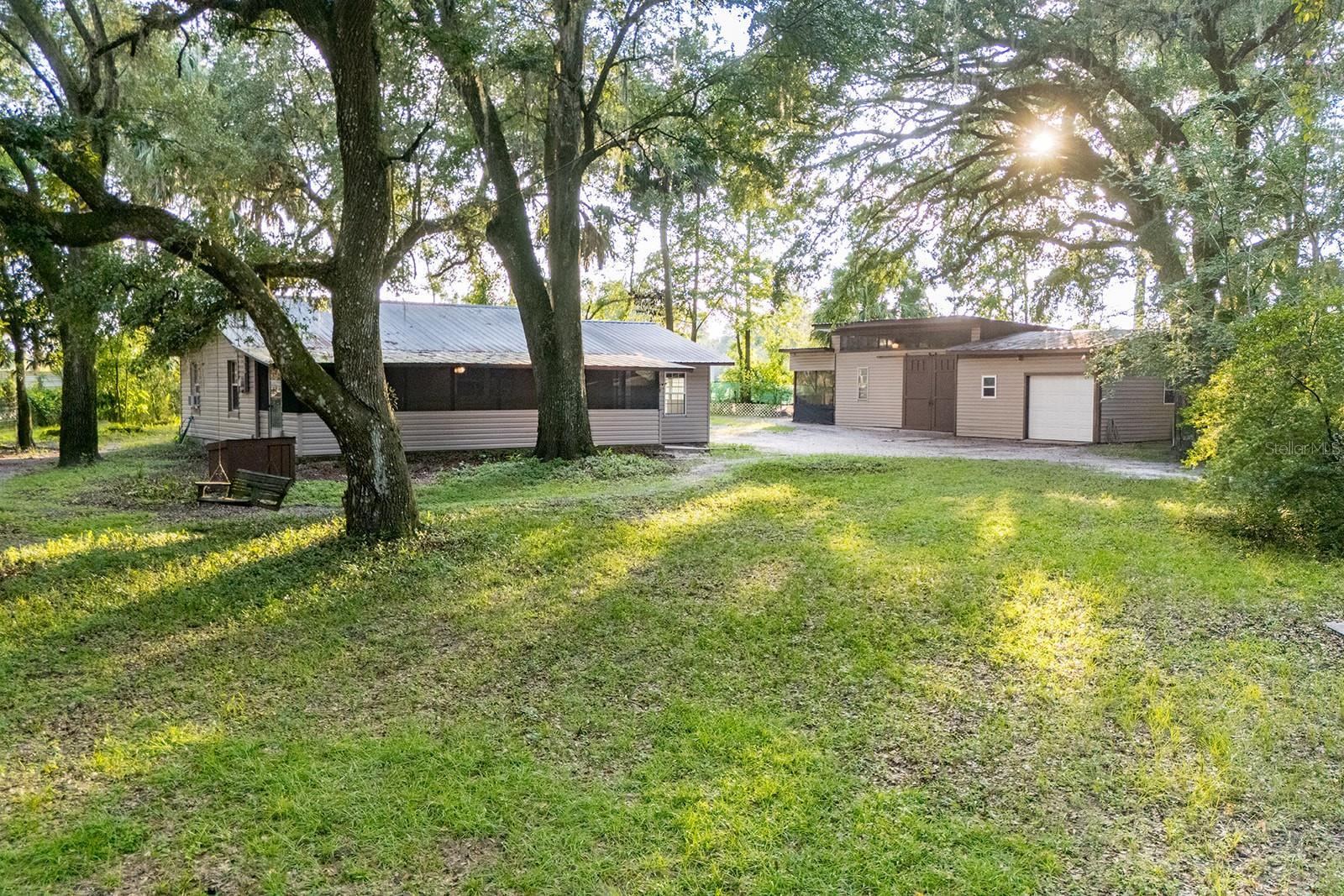 Discover the perfect blend of privacy and functionality with this charming 2-bedroom, 1-bath home tucked away in Hawthorne. Set on a fully fenced 1.22-acre lot, this property offers plenty of space for both relaxation and projects. Just a stones throw to Grove Park! Step inside to a cozy living space featuring a wood-burning fireplace, ideal for gathering on cool Florida evenings. The large screened front porch is perfect for sipping your morning coffee while enjoying the peaceful surroundings. Outside, you’ll find a detached oversized workshop, providing plenty of room for hobbies, storage, or even a small business setup. Whether you’re looking for a homestead, a quiet getaway, or space to expand, this property offers endless opportunities—all just a short drive from Gainesville, Palatka, and area lakes. All of this listed at under $250,000!!