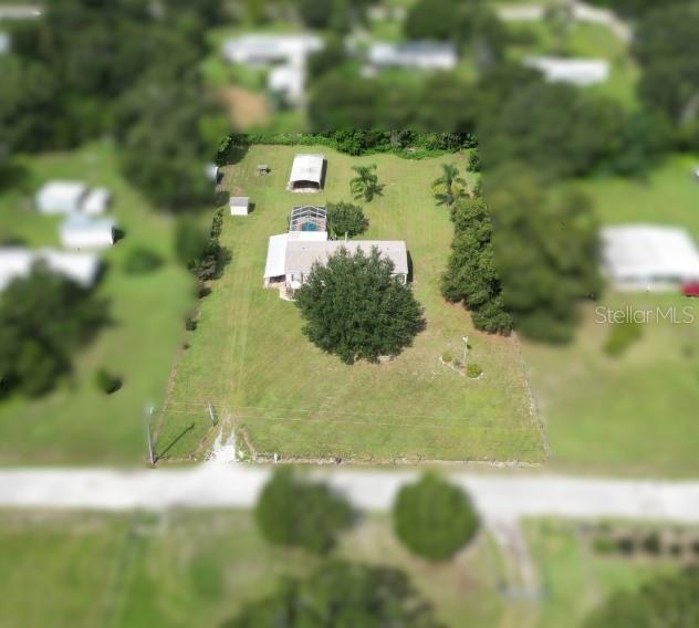 Country Living on 1.25 Acres – No Flood Zone! Discover the perfect blend of privacy and space with this beautiful 2003 Homes of Merit manufactured home situated on 1.25 acres of agricultural residential land. Located in a peaceful country setting, this property offers the freedom you’ve been looking for—no HOA, no CDD, no city restrictions, and no city taxes. This spacious home boasts 3 bedrooms, 2 full bathrooms, and 1,984 sq. ft. of living space. The open layout features a large living room with a cozy fireplace, a dining area off the kitchen, and a well-designed kitchen with an island bar, abundant cabinetry, and generous counter space—perfect for cooking and entertaining. Additional highlights include: An open front porch, Screened Florida room for relaxing year-round, Swimming pool for cooling off on warm days, Indoor laundry room for convenience, fenced property for added privacy and security, Well and septic system – no water or sewer bills, 2 carport detached garage with workshop. The agricultural zoning allows farm animals, making it an excellent spot for those who dream of raising chickens, goats, or starting a small homestead. There’s plenty of room for outdoor activities, gardens, more storage, and future improvements. Best of all, this property is NOT in a flood zone, giving you peace of mind with your investment. If you’ve been searching for a private rural retreat with endless potential, this is the one! Schedule your showing today and experience the country lifestyle you’ve always wanted!