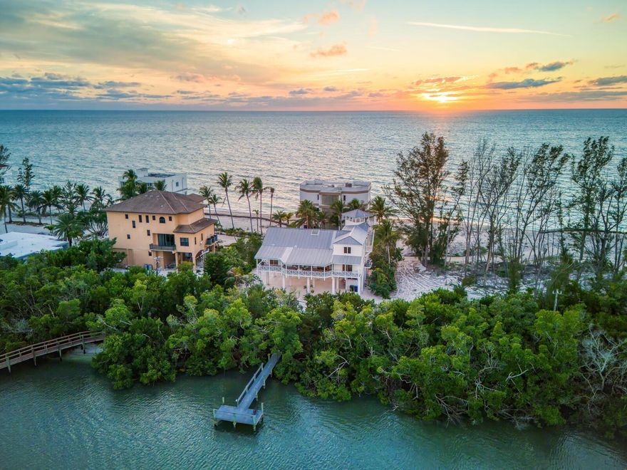 Gulf-to-Bay elegance meets relaxed coastal sophistication in this elevated, sailboat-access waterfront retreat, ideally positioned within one of Siesta Key’s most exclusive gated enclaves. Set in a rare peninsula neighborhood offering true Gulf-to-Bay living, this Caribbean-inspired residence delivers exceptional privacy, sweeping water views, and direct boating access with no bridges to the Intracoastal Waterway. With the newly reopened Midnight Pass just minutes away, access to the Gulf is effortless, making this an extraordinary opportunity for boaters and beach lovers alike.
Surrounded by mature tropical landscaping and located on a quiet dead-end street, the home enjoys both Gulf views and a tranquil basin setting with a private dock. Inside, a vaulted-ceiling great room anchors the main living level, filled with natural light and framed by sliding glass doors that open to expansive covered terraces on both the east and west sides—perfect for sunrise mornings and sunset evenings overlooking the water. The open-concept kitchen is designed for entertaining and everyday living, featuring premium appliances including a Sub-Zero refrigerator and generous workspace.
The primary suite is located on the main living level, offering terrace access and serene water views, while additional guest accommodations provide flexibility for family and friends. Above, a rooftop observation deck—accessible via spiral staircase—offers breathtaking 360-degree vistas spanning the Gulf, bay, and coastline, creating a truly unforgettable vantage point.
Thoughtfully constructed on pilings with storm-conscious design, the home blends timeless island style with peace of mind. The ground level provides covered parking for multiple vehicles, abundant storage, and space for kayaks, paddleboards, and beach gear. An elevator shaft is already in place for future installation, and pool plans are available.
With deeded beach access just steps away and a private dock at your back door, this is one of the few properties on Siesta Key where you can enjoy the beach in front and your boat behind. Beach, boating, privacy, and views converge in this exceptional offering—capturing the essence of Gulf-to-Bay living on Siesta Key. 
From morning experiences along the shoreline to breathtaking sunsets over the Gulf, every day on Siesta Key feels like a vacation. And when you're ready to explore beyond the island, downtown Sarasota is just a short drive away, offering world-class dining, arts and culture, including the Ringling Museum, Van Wezel Performing Arts Hall, and St. Armands Circle.