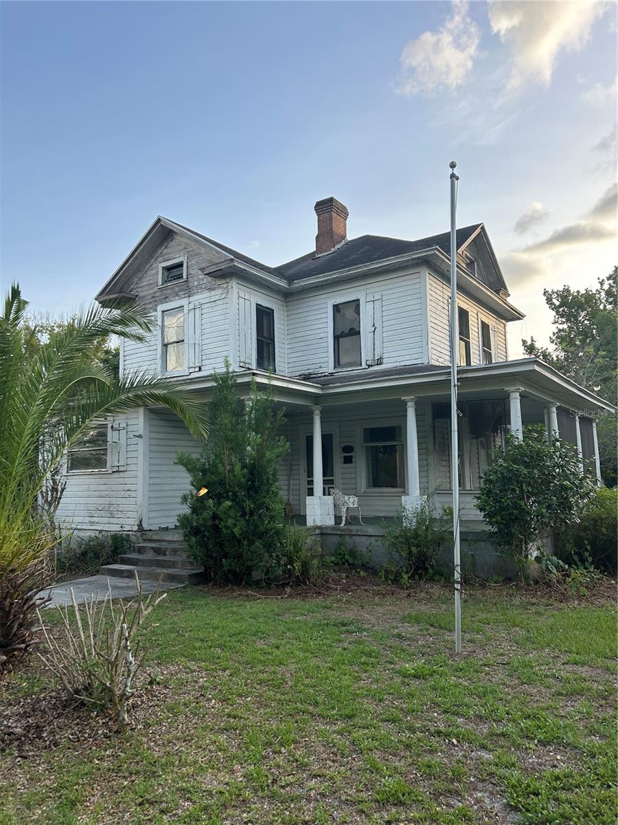 This grand old dame is tattered and worn and needs a significant amount of renovation but what a beautiful place it could be. Built in 1910, this beauty sits on a spacious corner lot with an array of flowering shrubs. Once restored, this would make a wonderful bed and breakfast or a beautiful historic home. The same family has owned this home since the 50s. Prior to that, it was a church parsonage, so only two owners in its history.
You enter from either side of the wraparound porch and let your imagination flow with an array of rooms downstairs to include living room, dining room, two bedrooms, bath and kitchen. The staircase extends from the living room and accesses the two bedrooms, bath, and study upstairs.
It truly could be a remarkable place as it has a lot of character. If the plaster walls could talk, you would find out a lot about days gone byl