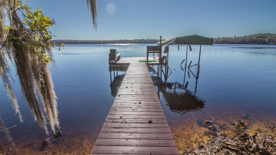 Privately nestled on 2.26 acres with approximately 150 ft of pristine lake frontage, this exceptional Redwater Lake estate offers a rare blend of elegance, tranquility, and natural beauty. The 2,512 square foot residence features 3-bedrooms and 2-baths, thoughtfully designed around a spacious open-concept living area that captures breathtaking, uninterrupted lake views.
Renowned for its serene setting and recreational opportunities, Redwater Lake provides an idyllic backdrop for refined waterfront living. The grounds are a lush, curated landscape showcasing mature trees, a dedicated butterfly garden, flourishing flowering plants, fruit trees, and classic Florida native foliage-creating a true private oasis.
Outdoor living is elevated with a screened enclosed that flows seamlessly onto an expansive open deck, ideal for entertaining or quiet reflection. A private dock with a boat lift offers effortless lake access, while a newly constructed, heated and fully irrigated greenhouse caters to the discerning gardening enthusiast.
This remarkable property is a rare offering - where luxury, privacy, and the beauty of nature come together in perfect harmony.