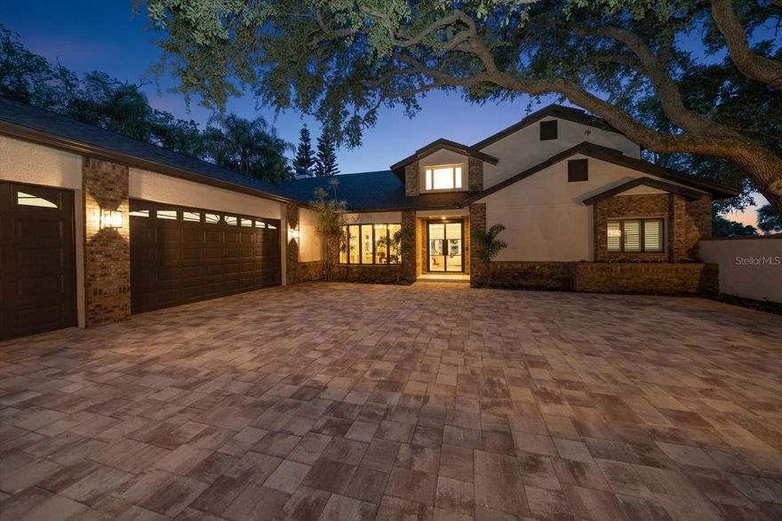 One of the most sought-after locations in the Tampa Bay area, this Spectacular 4 bedroom, 3 full/2 half bath, 3 car garage property situated on an elevated bluff overlooking the Intracoastal Waterway.  As you enter the new paver driveway--under the shady oak trees--you have arrived at your private waterfront oasis.  As you enter through the glass and steel front door you're greeted with amazing views and soaring ceilings! This home is designed to enjoy stunning views of the water and warm sunsets from every room! The open concept kitchen features expansive quartz countertops, bar seating, vaulted ceilings, and a new custom gas/electric fireplace with stacked stone accent in the enormous entertaining gathering area.  The French doors lead out to the covered porch with outdoor grill. The porches feature finished wood ceilings.  New custom finishes include new roof, engineered hardwood floors, new paint, new lighting fixtures and new ceiling fans throughout.  New natural gas appliances include tankless water heaters, cooktop, and gas grill.  There’s a huge laundry room with tons of storage.  The large three-car garage has new epoxy coated flooring.  The upstairs private primary suite is accessed by a gorgeous custom staircase with glass features.  It includes a private balcony overlooking the stunning grounds. The custom bath includes a freestanding tub and glass enclosed shower.  This private suite includes two large custom closets with built-ins.  The pool overlooks the massive grounds and intracoastal waterway. Pool upgrades include new pump, new filter, new natural gas heater and new pool lights.  Plus, there’s a convenient poolside half-bathroom.  The French doors from the living areas open to columned terraces and poolside decks ideal for entertaining or peaceful relaxation. Bring your boats, jet skis, paddleboard and fishing gear and enjoy the 80-foot composite dock that provides access to beautiful intracoastal waterway and views of the Belleair Causeway.