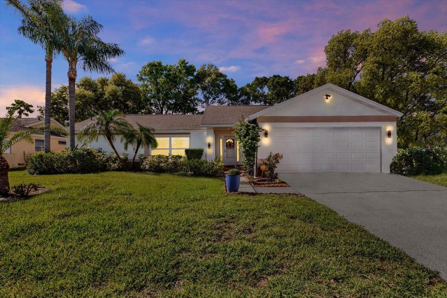 Welcome to this move-in-ready home in the highly sought-after, golf cart-friendly Fairway Springs community, perfectly positioned on a premium corner lot with Lake Saxon directly behind the property. This smart home offers a bright split-bedroom, open-concept layout with luxury vinyl flooring throughout, crown molding in the main living areas, and multiple French doors leading to the Florida room and private fenced backyard. The updated kitchen features Samsung Bespoke smart appliances in a sleek glass finish, including the Samsung AI Bespoke French 4-Door Family Hub refrigerator with touchscreen and a smart oven with built-in air fryer, complemented by granite countertops and a striking mirrored backsplash that enhances light and adds a modern, upscale touch. The spacious primary suite includes a walk-in closet, and the primary bathroom features a large smart anti-fog mirror with contemporary finishes. The secondary bedroom offers dual closets for added storage. Additional highlights include ceiling fans throughout, a smart thermostat, security cameras, a full alarm system, irrigation, and leaf-guard gutters. Major updates include fresh exterior paint (January), new roof (April), and new electrical panel (April). The oversized garage is equipped with a utility sink, workbench, wall-mounted cabinetry, and attic storage. Ideally located close to the community pool and clubhouse, adjacent to Seven Springs Golf & Country Club, just minutes from Trinity, shopping, dining, and Gulf beaches, and conveniently close to Longleaf Elementary School, this home offers an exceptional combination of upgrades, location, and lifestyle.