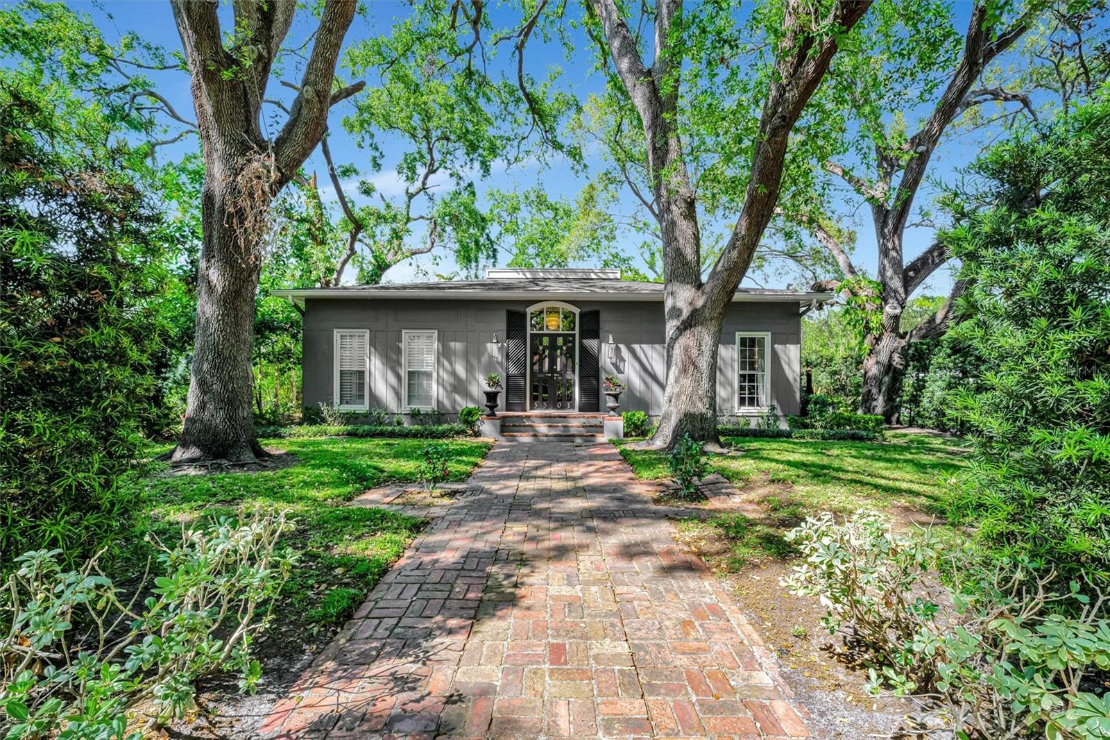 Nestled in the highly regarded Golf View Place neighborhood of South Tampa, this elegant 3-bedroom, 4-bathroom residence offers more than 2,500 square feet of thoughtfully designed living space on an expansive 8,712 square foot lot. From the moment you arrive, the home’s refined character is evident, welcomed by a charming brick entryway and French-style wood-paneled doors with decorative glass. Inside, upscale details abound, from the grand foyer with a statement chandelier to the formal sitting area illuminated by an Aquitaine round fixture. The spacious family room exudes warmth and sophistication, featuring a working brick fireplace, built-in shelving and cabinetry, and a designer ceiling fan. The chef-inspired kitchen is beautifully appointed with floor-to-ceiling custom cabinetry, stainless steel appliances including a range with hood and double-door refrigerator, and a natural wood dining table for six, offering both style and practicality. The primary suite provides a peaceful retreat with a walk-in closet, an elegant chandelier, and a spa-style en-suite bath complete with granite counters, custom shelving, a glass-enclosed soaking tub, and a separate walk-in shower. Upstairs, additional bedroom and a custom small den for flexible space for guests, work, or relaxation. Step outside to a private outdoor haven where sliding doors open to a brick-paved patio featuring a concrete fire pit surrounded by pebble landscaping, a sparkling pool, and a shaded lounge area. Mature oak trees, a privacy fence, and professional landscaping enhance the serene setting, while the attached two-car garage adds convenience for everyday living. This home is also available for lease and can be rented for up to six months, with the possibility of longer stays upon request. Short-term rentals under 30 days are also accommodated. Please note, actual rental rates will vary based on the duration of stay and time of year. Pets are welcome for an additional fee. Ideally situated just moments from Palma Ceia Golf & Country Club and zoned for top-rated Grady Elementary, Coleman Middle, and Plant High School, this meticulously maintained home blends timeless architecture, modern comfort, and a premier South Tampa location, offering a lifestyle of elegance, ease, and convenience.