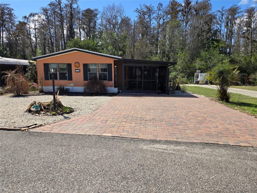 OWN YOUR OWN LAND!  55+, pet friendly, community of neighbors! This charming updated home offers 2 bedrooms and 2 bathrooms, perfect for those seeking a comfortable and low-maintenance lifestyle.  Landscaped yard and a paver driveway.  The open floor plan provides a spacious, light & bright, inviting home. Updated flooring, AC with HEAT PUMP and all duct work replaced just 5 yrs ago.  Beautifully updated kitchen features has granite countertops, lots of work space, updated appliances, deep double sink and a beautiful stained glass window!. Both bathrooms are updated. The Laundry Room is just off the kitchen and has a closet pantry.  Located on the parameter of the community, the rear patio lets you enjoy nature and privacy!  This community is delightfully peaceful/quiet while providing plenty of social enjoyment, a community pool, dog park, clubhouse, gym and shuffleboard. Enjoy the attached video then make an appointment to see this one.  Best price, too!