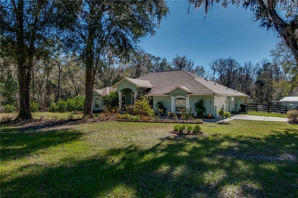 Under contract-accepting backup offers. Perfectly placed within the historic Marion County area of Micanopy, this attractive executive home has great curb appeal and has been lovingly maintained! Resting on a large corner lot along Highway 320, the property features a stunning setting accented by tasteful landscaping and mature trees. Offering a total of 4-bedrooms and 3-bath, the home features stunning attention to detail with an open, split-bedroom floor plan, high cathedral ceilings, some tray ceiling accents, and ceramic tile and real wood flooring throughout. For those who enjoy spending time cooking, the kitchen is well-equipped with plenty of cabinet space, expansive granite countertops, tiled backsplash, stainless steel appliances, breakfast bar, and a spacious breakfast nook with views of the backyard. Updates to the kitchen include the new countertops and new stainless steel appliances including a new range with double oven as of 2022. The main living area is adjacent to the kitchen, providing an easy flow of conversation between both spaces. All bedrooms are spacious, but the master suite is truly special with a larger layout, tray ceilings, and a private en-suite with a huge walk-in closet, dual vanities, large garden tub, and walk-in shower with dual shower heads. To the back of the home is a gorgeous enclosed lanai that is perfect for relaxing or simply sipping coffee in the morning. There are several upgrades that can be found throughout the home including a new AC in 2022, a newer water softener, a new metal roof on the shed, new exterior paint as of 2020, and a Vivint security system! Beyond the lanai is a black 4-board fenced-in area of the backyard, complete with a Ghost remote controlled auto gate opener, that is perfectly suited for four-legged friends to enjoy some time outside. Two outbuildings are also located in the backyard– one currently serving as a workshop and the other as a storage shed for equipment. Both Ocala and Gainesville are less than a 30 minute drive away, offering access to a variety of shopping, dining, event, and medical options without much fuss, and with the World Equestrian Center and Jockey Club a short 6 miles as well! Those who enjoy spending time outdoors will love the highly convenient location near a variety of lakes, trails, and even Paynes Prairie Preserve State Park. If you’ve been searching for a stunning home with a private but convenient location, look no further!