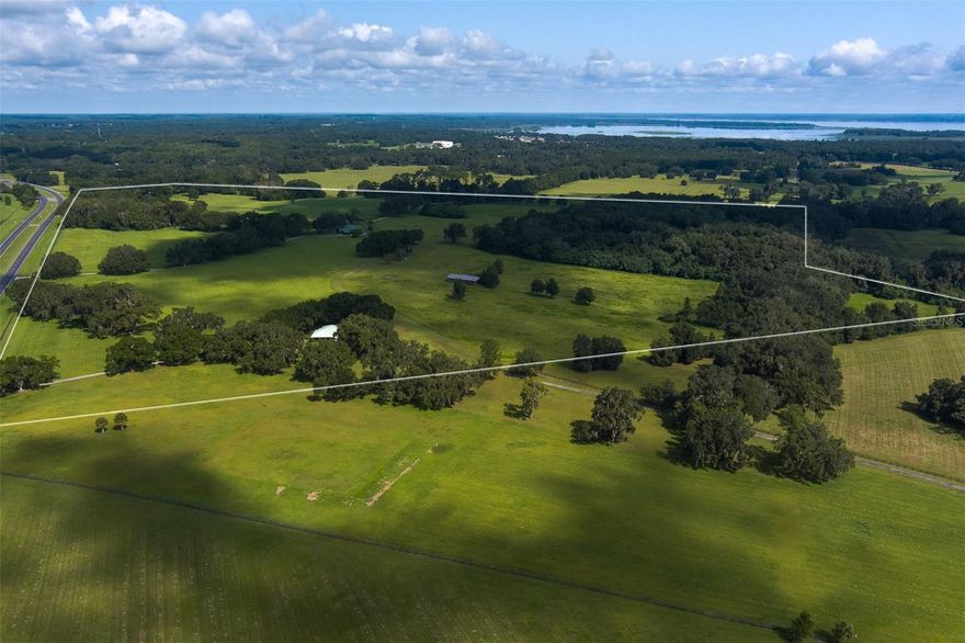 This gorgeous 132+ acre property personifies the Ocala horse country landscape with its rolling green pastures, grandaddy oaks, and plethora of wildlife. With 132 acres, you will have your own private horse park.  This property is conducive to an income producing endeavor, however, its privacy and peacefulness present an idyllic setting for any venture.  Whether operating a show stable or riding the gently rolling fields and woodland trails under the farm's "big skies", life is so grand you will not want to leave. But should you decide to venture out, this farm is the epicenter for all Central Florida has to offer.   The esteemed World Equestrian Center, as well as Ocala, and Gainesville, can be reached in 30 minutes or less; the new WEC at Ocala Jockey Club is just 5 miles away. Major airports and both the East coast with available beach horseback riding, and the West Coast, are all day trips.  The Solred House provides 2 BR/2 BA, laundry room, office/den, spacious family room, and large doors and windows allowing panoramic views. It features brick flooring throughout the main living areas, arched drive-through carport, and a patio with concrete pavers. The 2 BR/1.5 BA Cottage in the Woods includes an open kitchen, living room, spacious great room, laundry room, and side patio. This farm includes a 16-stall center-aisle barn with 12'x13' matted stalls, office with viewing area with 1/2 bath, feed, tack, and storage rooms, and laundry. There is a wash rack, loading chute, round pen, and both electric and board fenced paddocks. The center-aisle Quarantine Barn provides another 6 stalls with 15'x15' matted stalls, wash rack, open breeding or storage area, breakroom, bath, and storage rooms.