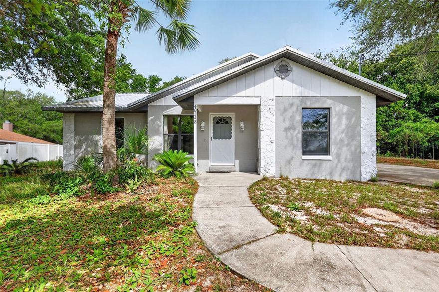 A water view and nearly half an acre to enjoy! The home features durable block and stucco construction for lasting quality and curb appeal. A winding sidewalk leads to the front door, creating a warm and inviting entrance. This 3-bedroom home features a desirable split-bedroom floor plan, offering both comfort and privacy. Recent updates include a durable metal roof, brand-new tile flooring throughout (2025) the home offers a clean, stylish look with easy maintenance, a new hot water heater for peace of mind, and fresh interior paint—making this home truly move-in ready. Bright and spacious living room filled with natural light, creating a warm and inviting gathering space.

Double pocket doors lead to your private owner’s suite—close them to create a quiet retreat with direct access to your bathroom. This bedroom and bath also feature pocket doors, providing added privacy for family or visitors.

Step directly from your suite onto the expansive 12' x 39' screened lanai and unwind in the evenings with a drink and great conversation. The private backyard with plenty of space for outdoor entertaining, gardening, pets, or simply relaxing. Wide driveway with plenty of room to add a garage or carport. Located in a quiet neighborhood, this home offers a peaceful and relaxing atmosphere. If you have been waiting for a home in a rural setting with just enough land, this is the home for you!

Conveniently located just minutes from shopping, dining, and The Villages, this home offers the ideal blend of space, updates, and location.