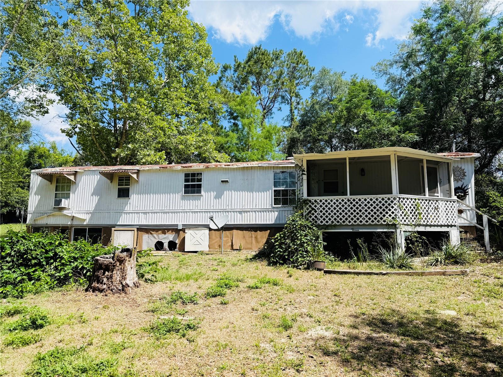 Welcome to 10541 SE 127th Ln Belleview Fl. Located minutes away from the Villages, Big Lake Weir and Carney Island State park. This lovely MH sits on almost 1 acre land, no Lot rent or HOA. Inside, you'll find a spacious and functional layout featuring an open living, dining, and kitchen area with vinyl and title flooring throughout and to right the master bedroom that features a bonus room off to the side. Step outside to your private oasis, featuring a refreshing pool with a recently installed deck, perfect for entertaining or enjoying peaceful Florida evenings. Perfect for investors, first-time buyers, or those looking for a flip-and-fix opportunity.
