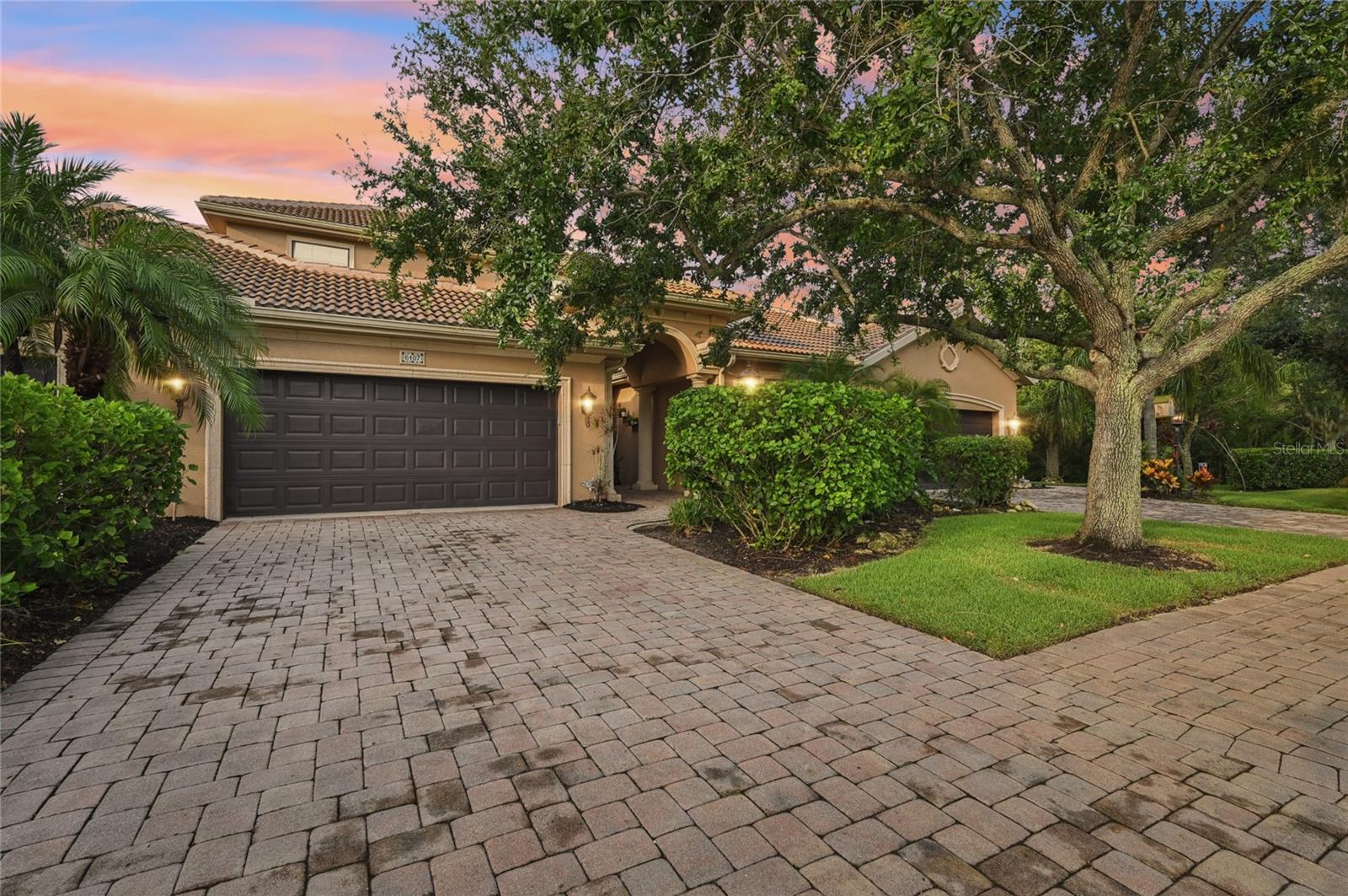 Tucked inside the gates of Bougainvillea Place, a quiet, resort-style community where everyday life feels like a getaway, you’ll find this Mediterranean-inspired townhome that’s as inviting as it is impressive. Homes rarely come on the market in this community and you can see why from the moment you step into the private pavered courtyard. Surrounded by lush greenbelts, lighted fountains, and tranquil water views, this is Florida living at its finest—without the burden of CDD fees. Inside, soaring ceilings and crown molding frame a layout designed with both comfort and style in mind. The heart of the home is the kitchen, where rich hardwood cabinetry, granite countertops, and stainless steel appliances meet around a large island with a high-top breakfast bar—perfect for meals on-the-go. A convenient half bathroom sits nearby, thoughtfully placed for guests. The first-floor owner’s suite offers a true retreat, complete with hardwood floors, double walk-in closets, and a spa-like bathroom featuring a soaking tub, dual vanities, and a large glass-enclosed shower. Take the beautiful wood staircase upstairs leading to a cozy loft space—ideal for a reading nook or second living area. A second ensuite bedroom provides privacy for guests, while two more bedrooms share a Jack and Jill bath, making this home perfect for years to come. Step outside to the covered lanai and take in the peaceful views of the lush protected preserve and pond with a lighted fountain. Whether you’re enjoying a quiet evening or entertaining friends, this outdoor space feels like a little slice of Floridian paradise. The HOA takes care of all exterior maintenance, including lawn care and roof replacements, so you can enjoy a truly low-maintenance lifestyle. Life at Bougainvillea Place means more than just a beautiful home. It’s about the experience—lounging by the seasonally heated pool in your private cabana, hosting gatherings in the clubhouse, walking your dog through the park, or getting in a morning workout at the fitness center. = And with the Ellenton Outlet Mall just minutes away, plus quick access to I-75 and US-301, you’re never far from the best that St. Pete, Tampa, Sarasota, and Lakewood Ranch have to offer. Come home to a place that’s more than just a home—it’s a lifestyle. Welcome to Bougainvillea Place.