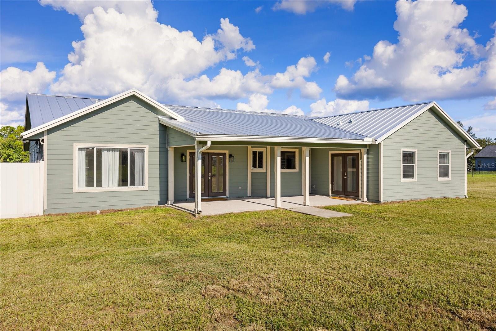 COUNTRY LIVING minutes from all Central Florida has to offer : This custom home sits on nearly 5 acres with AG zoning, an in-law suite, and multiple outbuildings. Recent upgrades include a new metal roof (2021), exterior and interior paint, a split A/C for the owner’s suite, a whole-house surge protector, and a propane generator with an owned tank. The oversized owner’s suite features a private porch, brand-new luxury bath, and a massive walk-in closet, while the in-law suite offers its own entrance and bath. A bright kitchen with updated cabinetry and appliances complements the living space. Outside, you’ll find a fully equipped metal shop, detached garage/pole barn, 4-stall barn, cross-fencing, and a pond with irrigation—perfect for livestock and hobbies. Nestled in Gentry Farms with no HOA, this property offers privacy and a rural feel yet remains close to Lake Nona, Orlando attractions, beaches, and a charming downtown.
